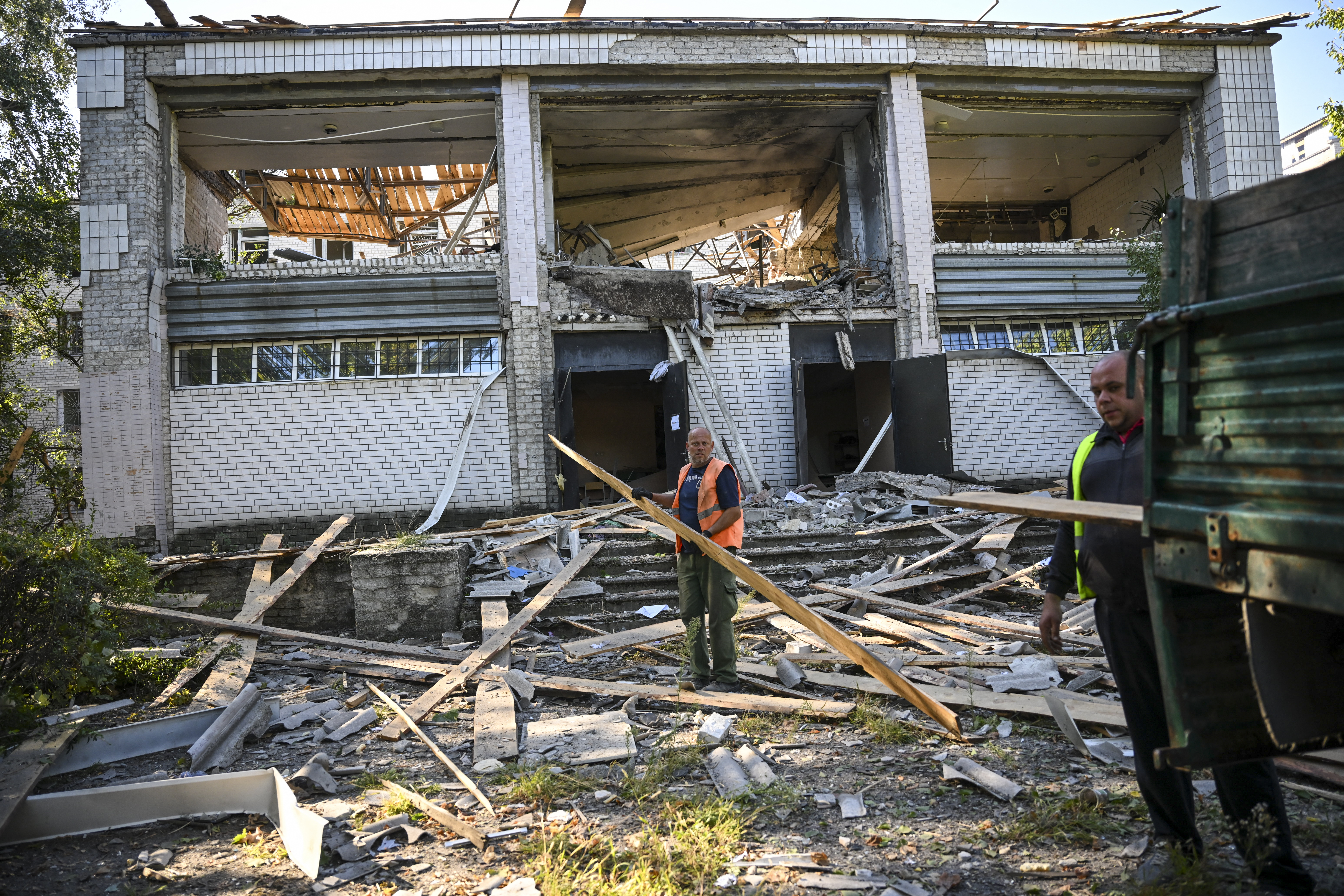 Workers collect debris from a psychiatric hospital