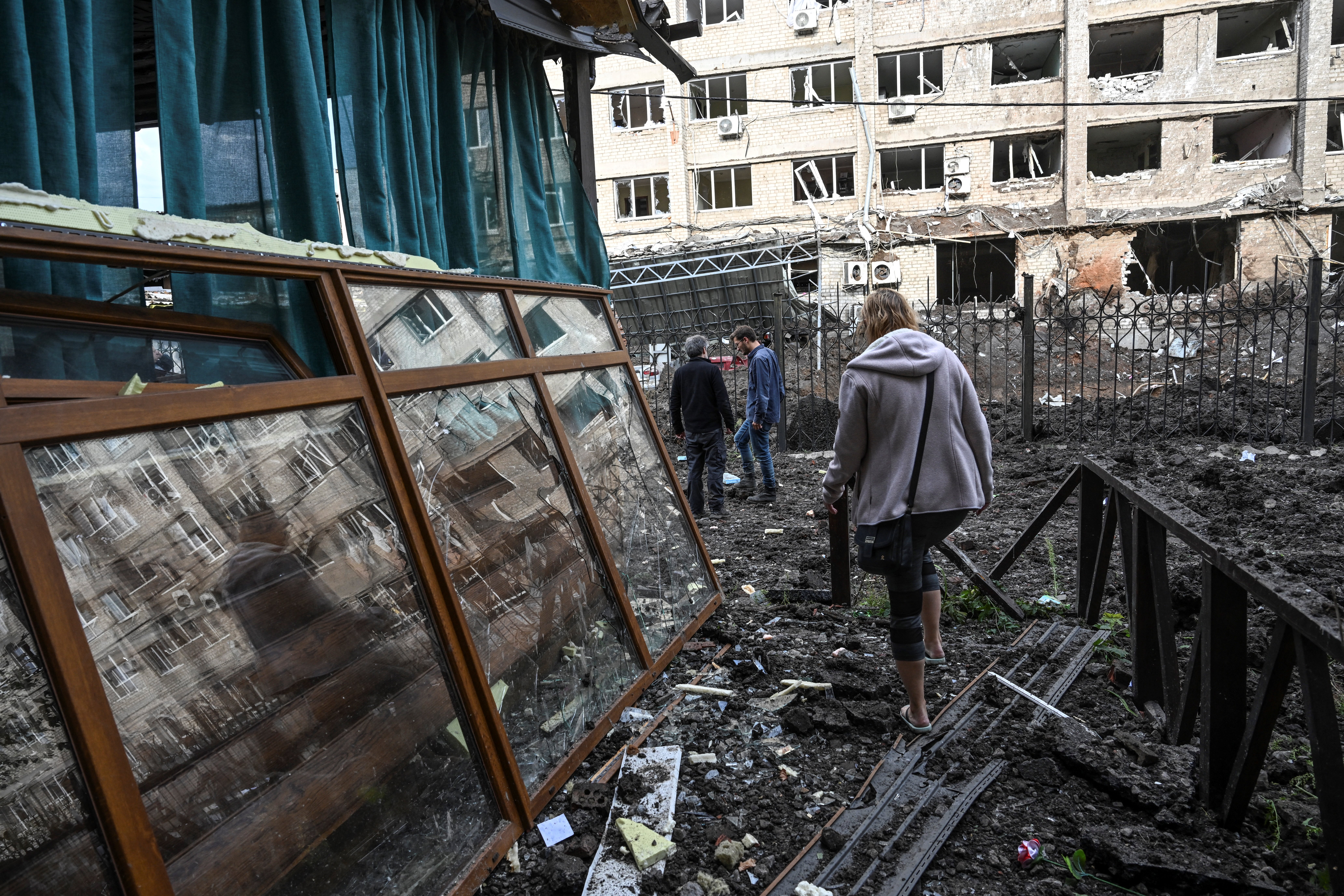 A woman walks in front of a destroyed building in Kramatorsk, in the Donetsk region on September 18, 2022, amid the Russian invasion of Ukraine. (Photo by Juan BARRETO / AFP)