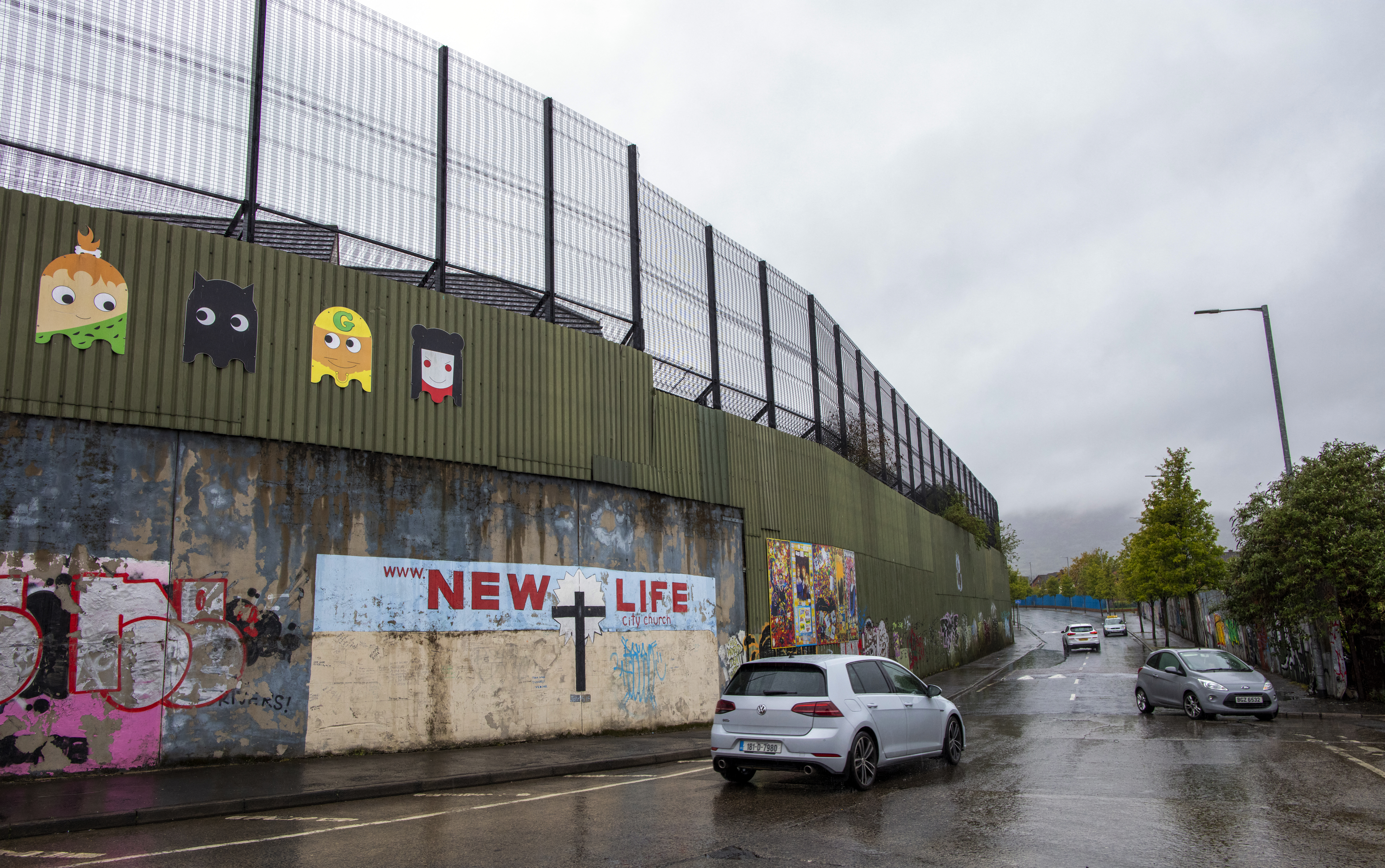 Cars drive around the Peace Line