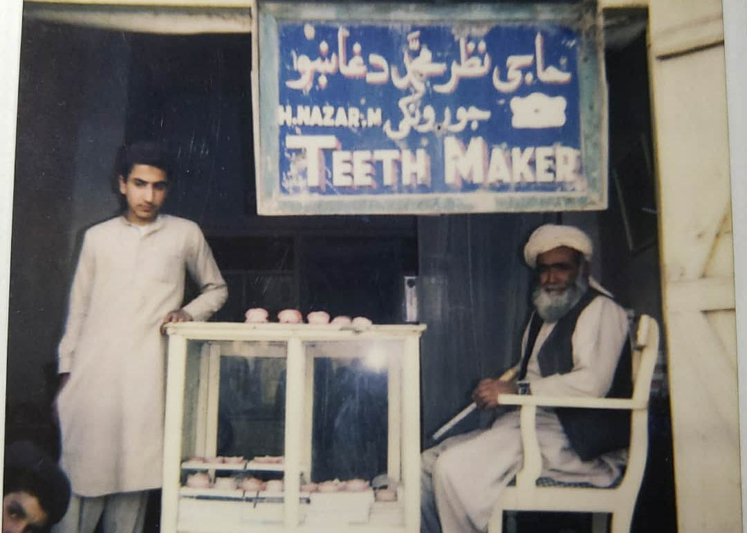 A photo of two mean with a sign that says 