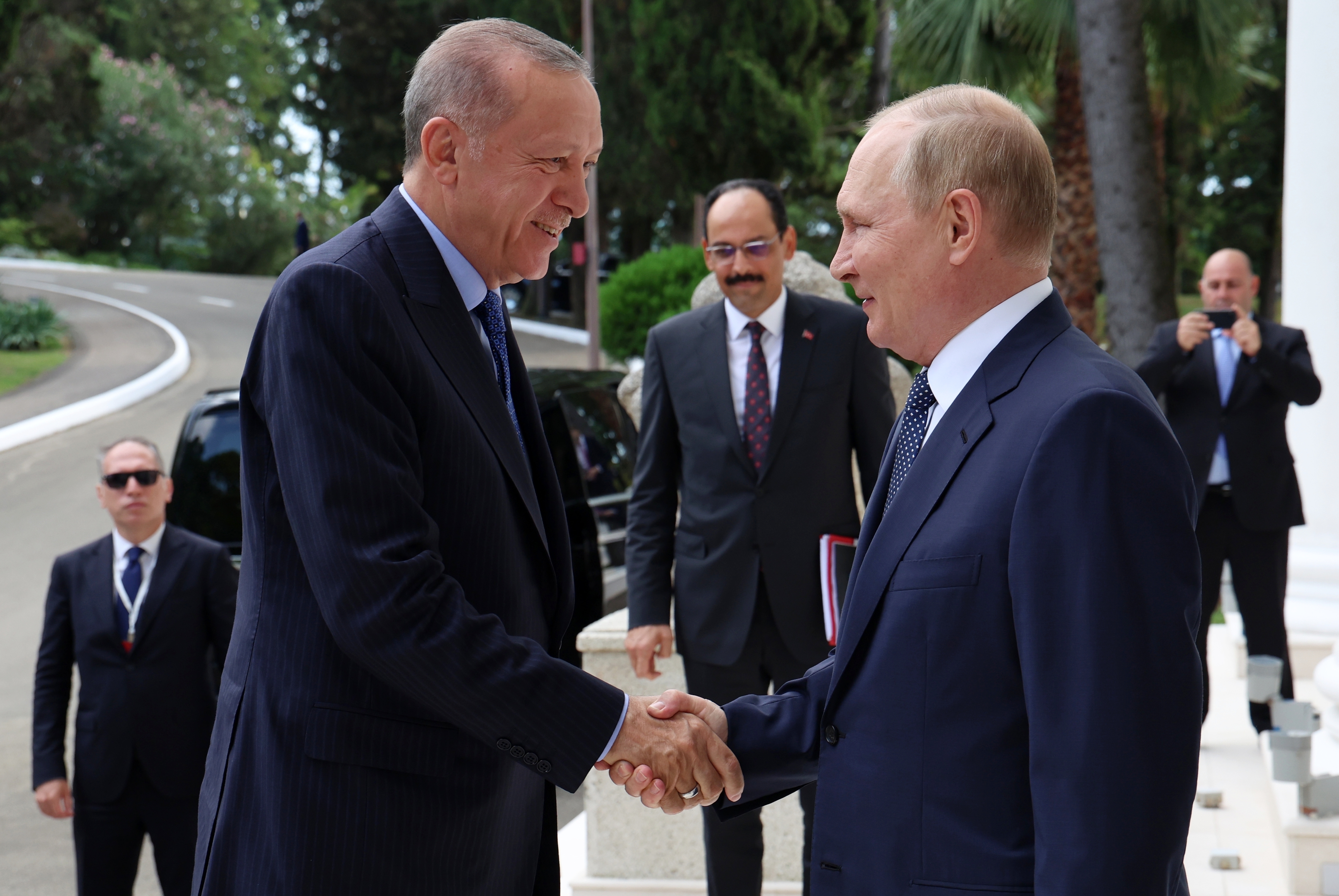 Russian President Vladimir Putin, (right), greets Turkish President Recep Tayyip Erdogan upon his arrival at the Rus sanatorium in the Black Sea resort of Sochi, Russia, Friday, Aug. 5, 2022. Erdogan's spokesman Ibrahim Kalin is the center. Turkish President Recep Tayyip Erdogan traveled to Russia Friday for talks with Russian President Vladimir Putin expected to focus on a grain deal brokered by Turkey, prospects for talks on ending hostilities in Ukraine, and the situation in Syria. (Vyacheslav Prokofyev, Sputnik, Kremlin Pool Photo via AP)