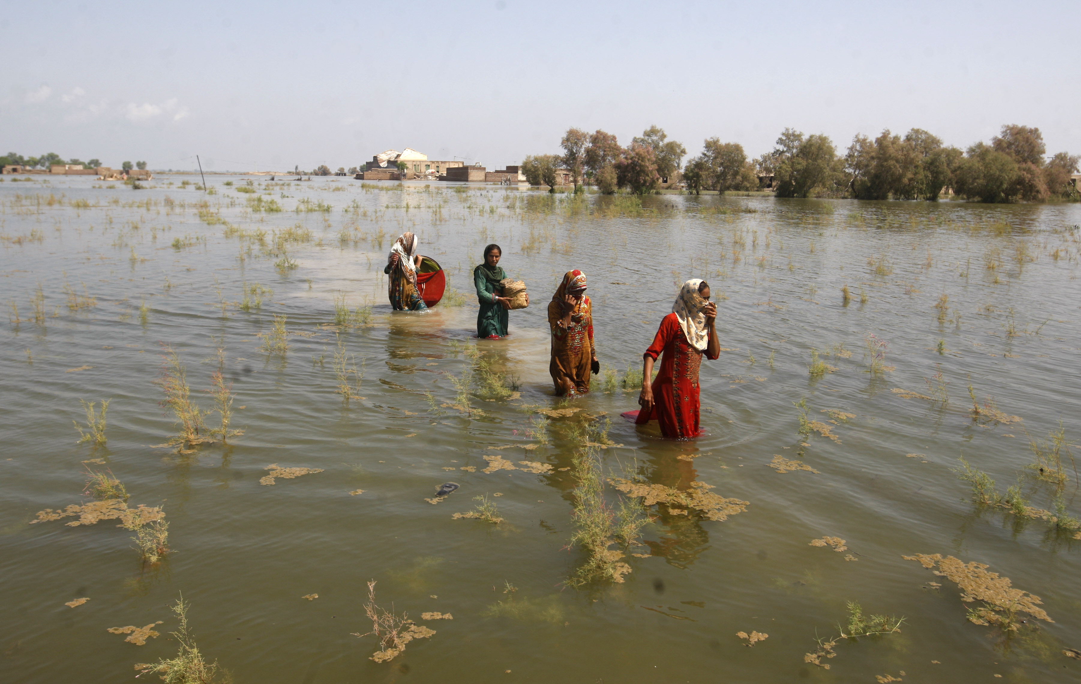 Pakistani women wade through floodwaters