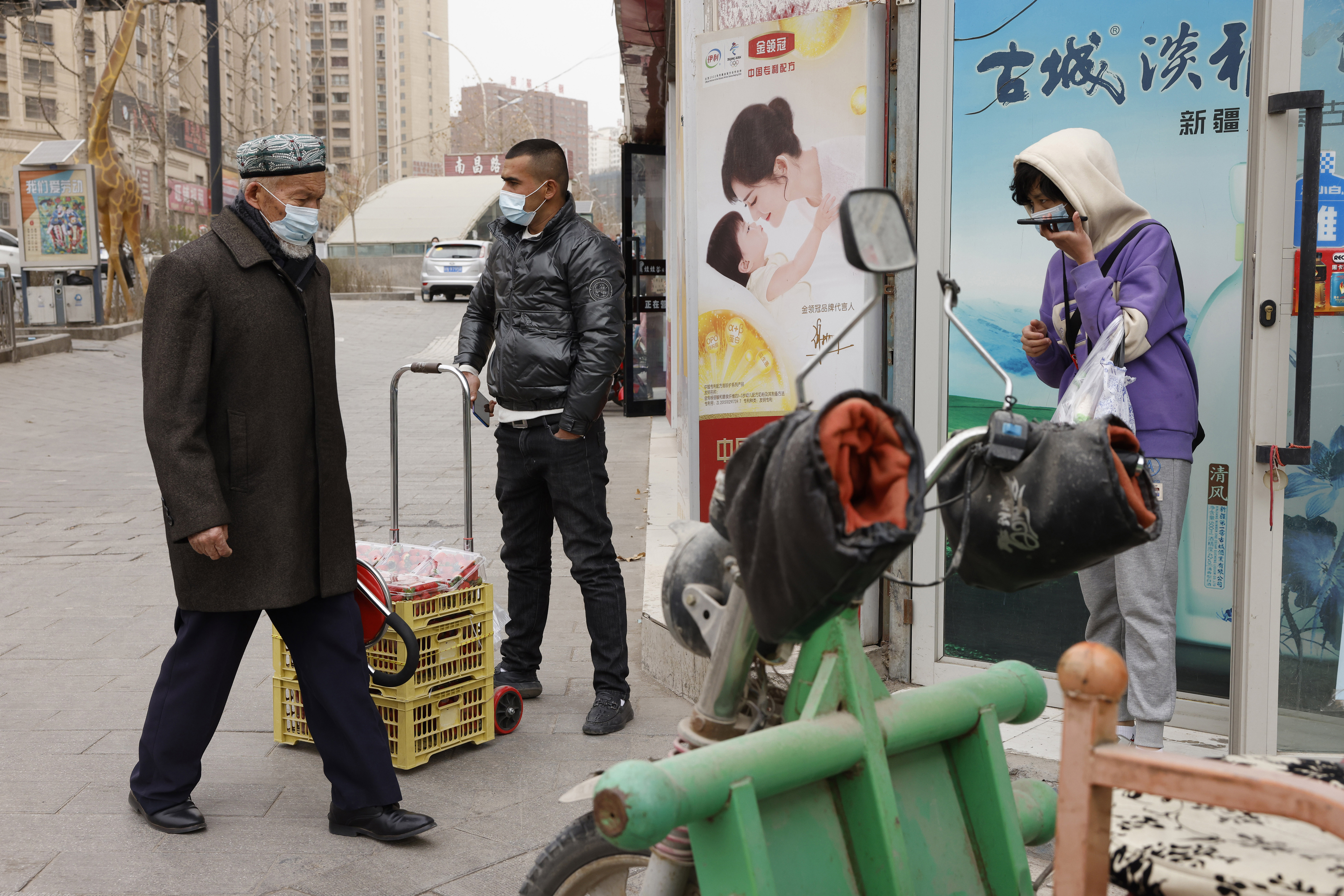 People in Aksu in Xinjiang walking the streets in masks in March 2021.