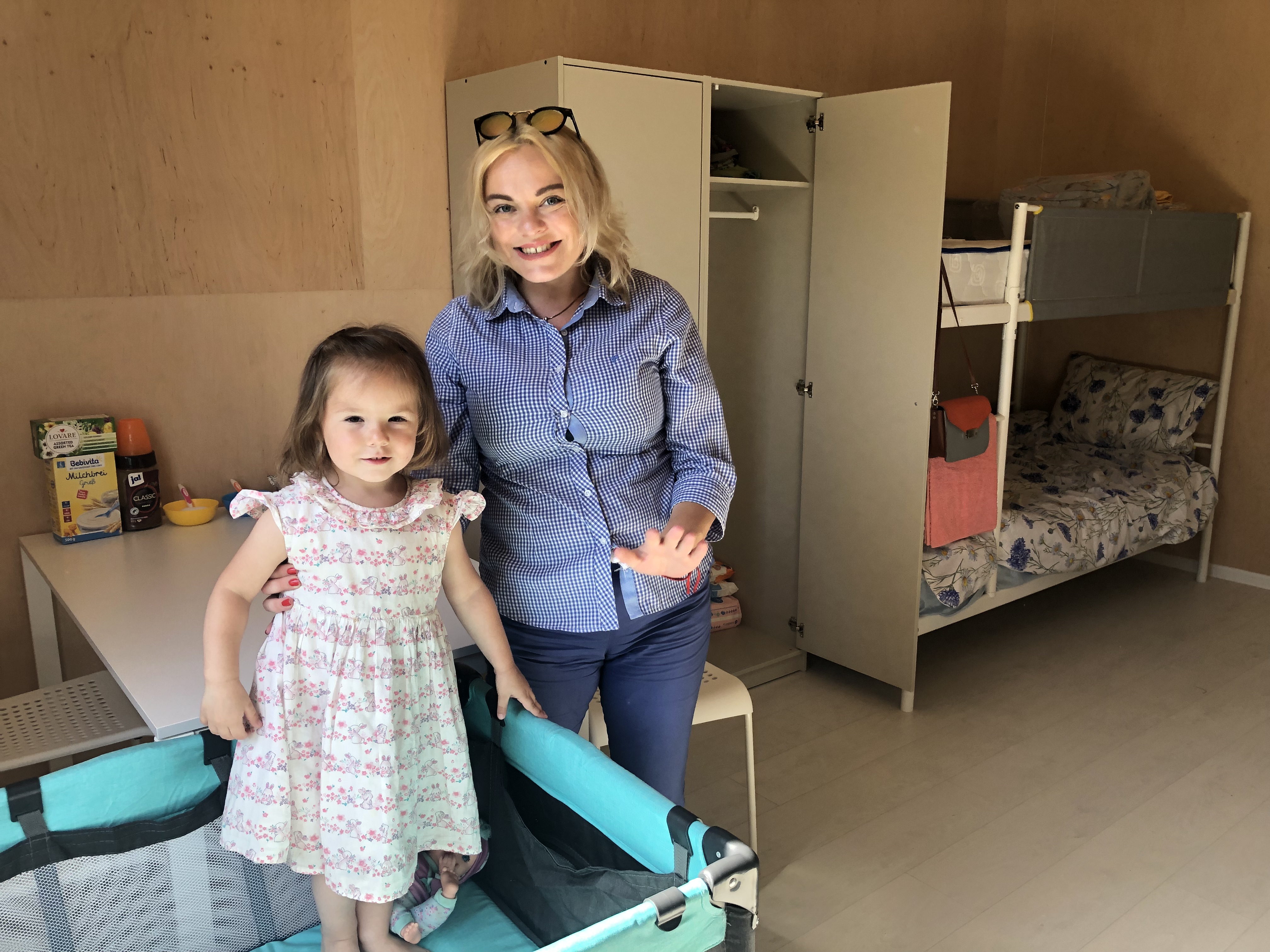 Anna with her daughter, who is wearing a dress.