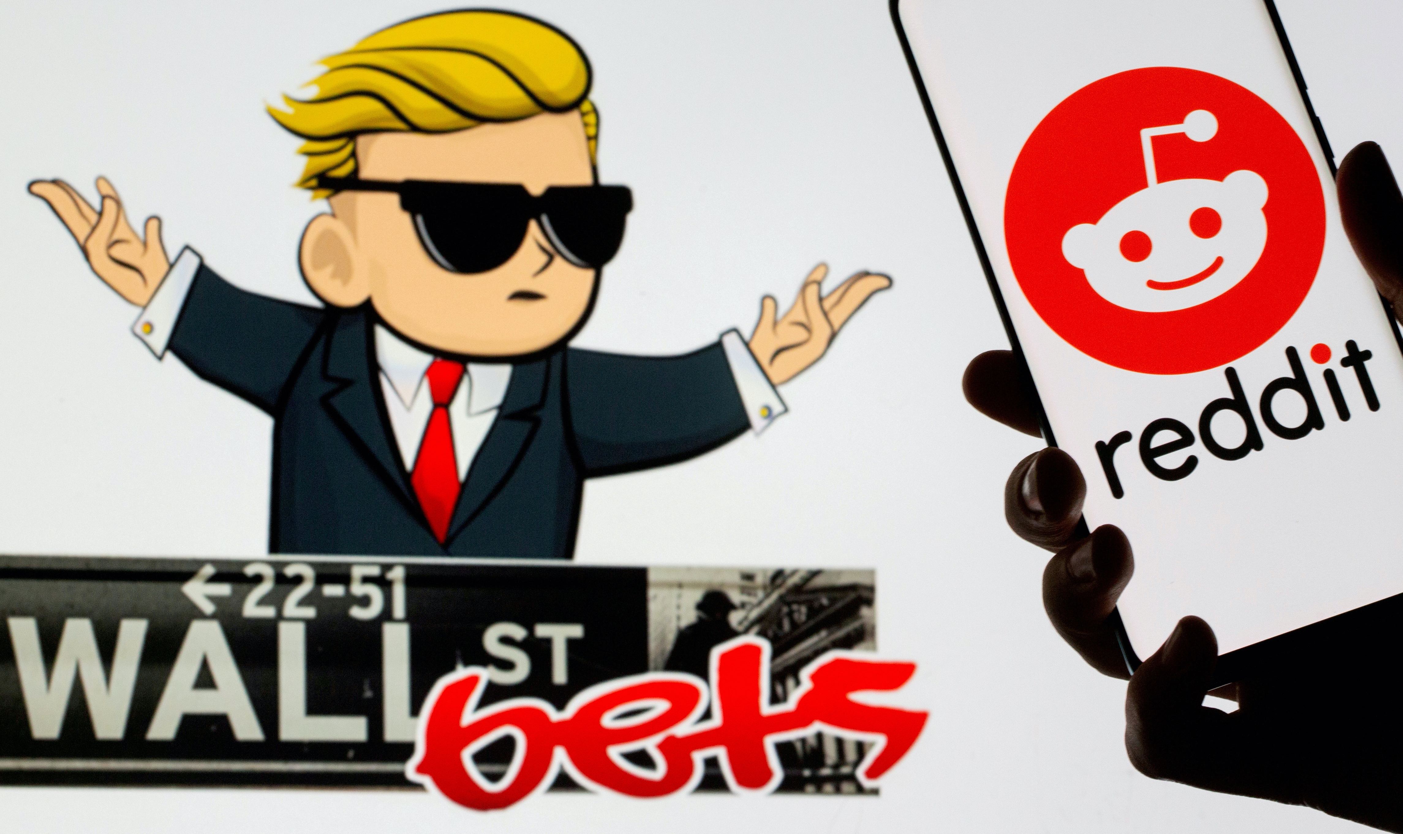 The Reddit logo is seen on a smartphone in front of a displayed Wall Street Bets logo