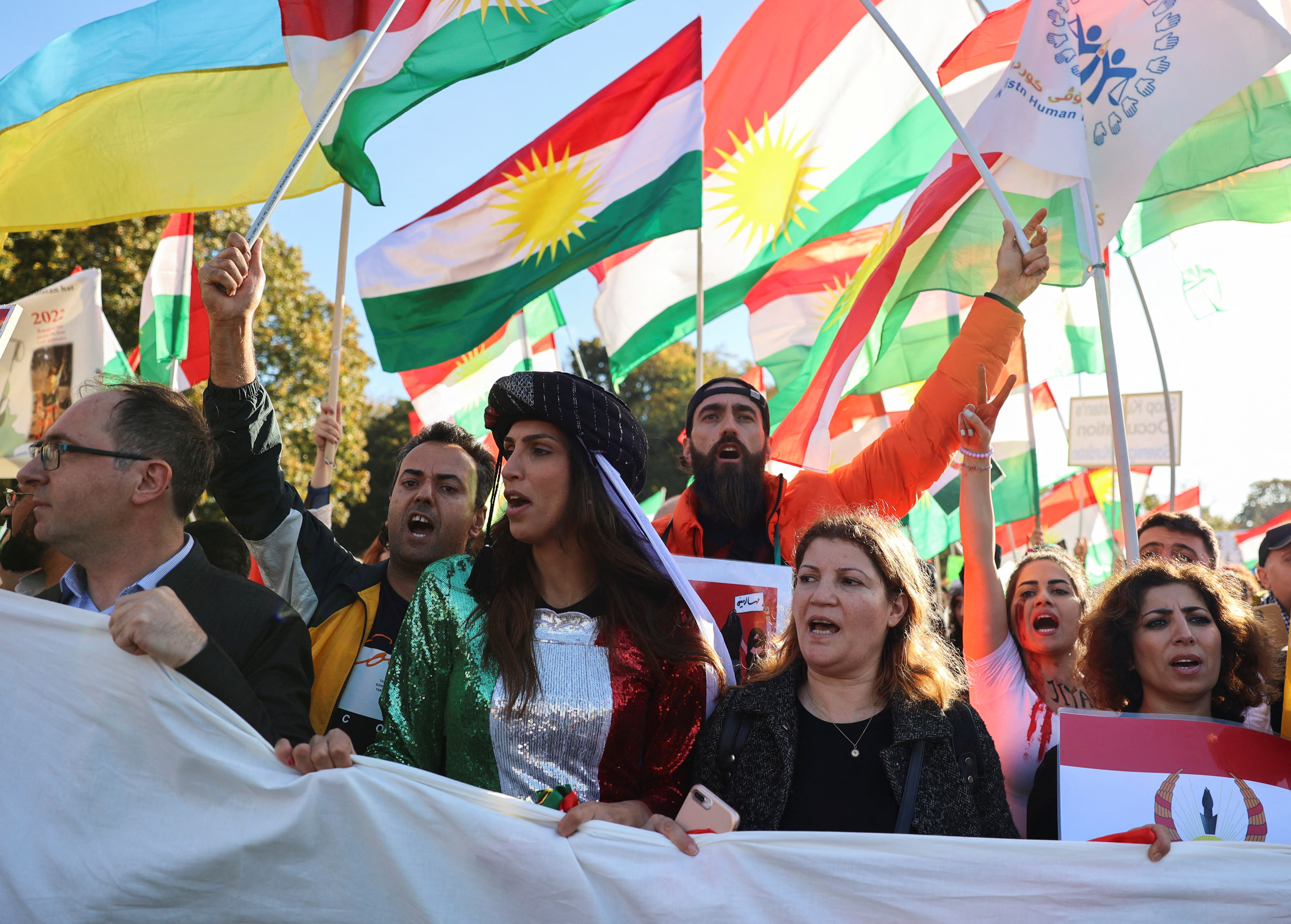 Demonstrators hold a banner and flags during a protest following the death of Mahsa Amini in Iran, in Berlin.