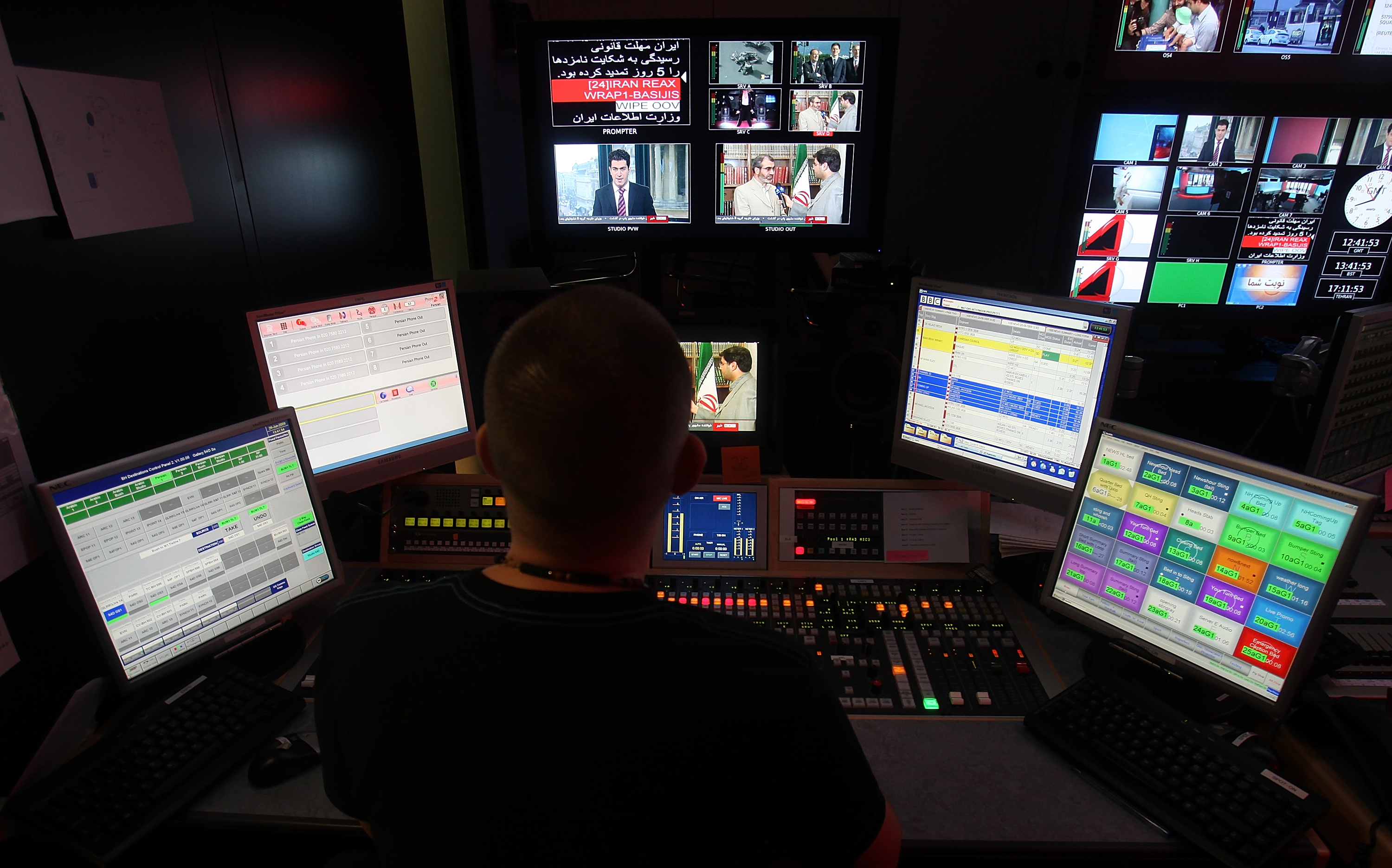 A BBC Persian service sound engineer watches, as Fardad Fazahzad presents the news at the corporation's London headquarters, Friday June 26, 2009. Inside the studios of BBC Persian television, dozens of journalists have been working around the clock at their computers and telephones, trying to report the news to Iran or, according to the government in Tehran, stirring up trouble. (AP Photo/Simon Dawson)