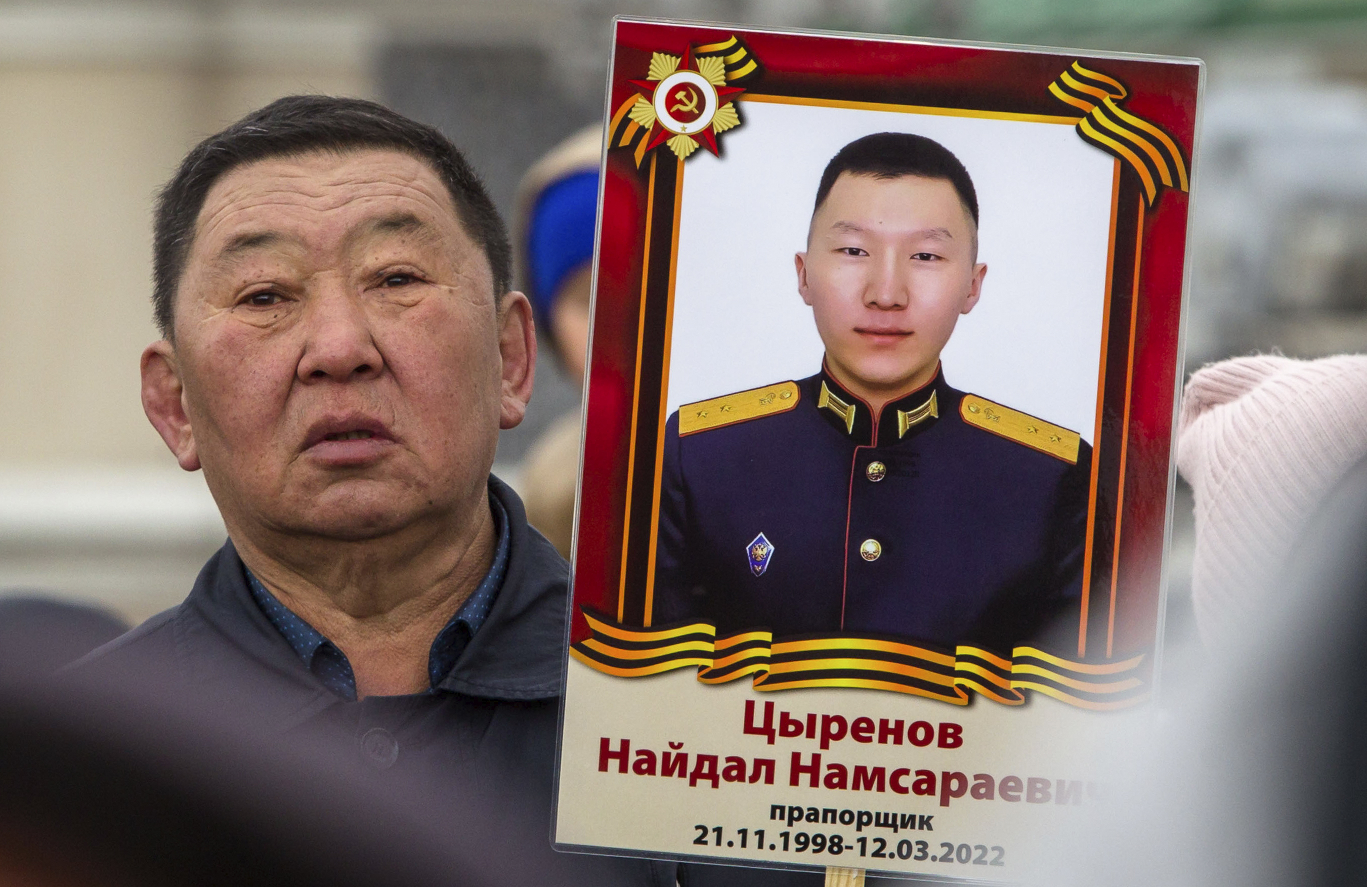 A man holds portrait of Russian Army officer Naidal Tsyrenov, who was killed during fighting in Ukraine, during the Immortal Regiment march in Ulan-Ude, the regional capital of Buryatia, a region near the Russia-Mongolia border, Russia, Monday, May 9, 2022, marking the 77th anniversary of the end of World War II. (AP Photo)