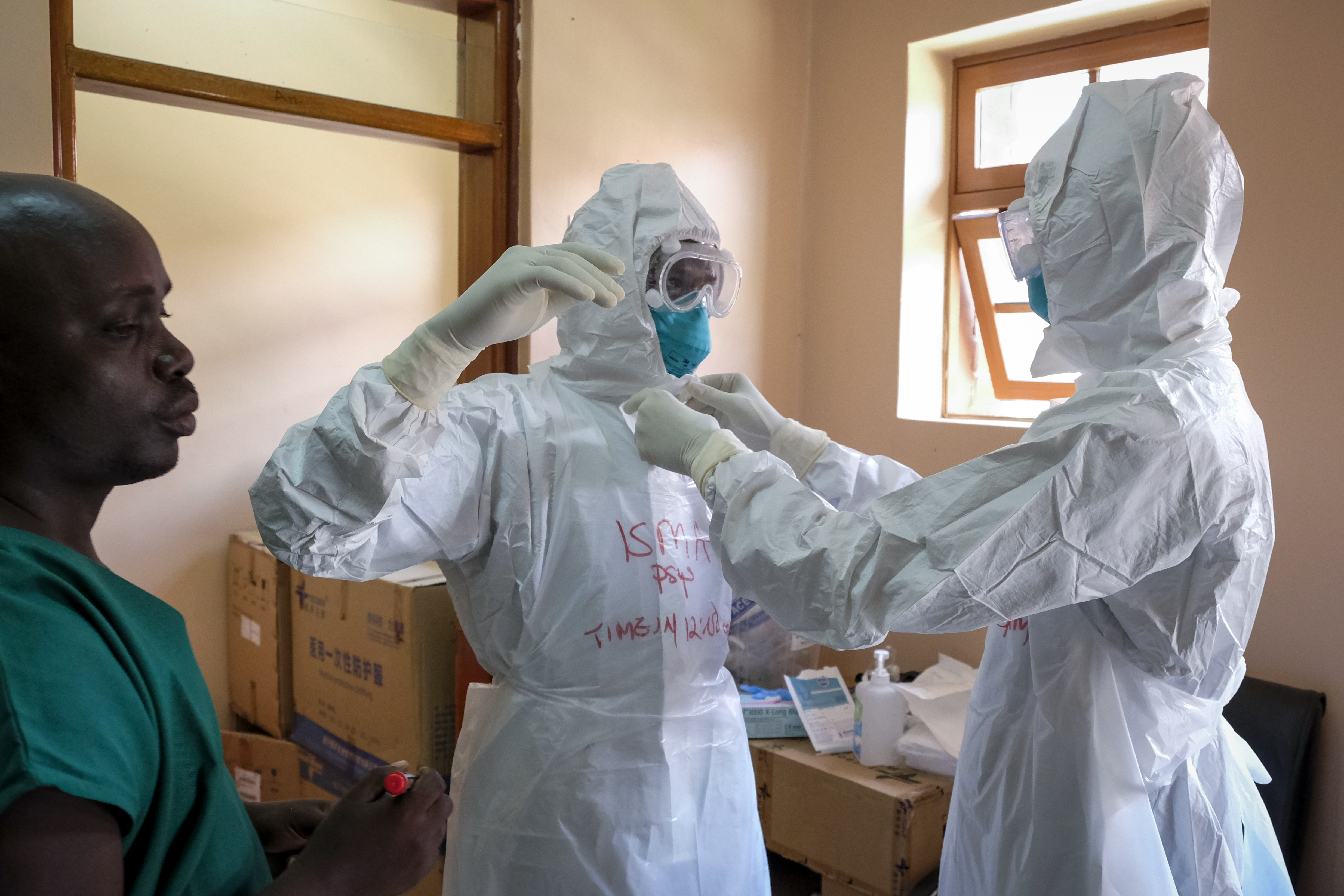 Doctors put on protective equipment in Entebbe, Uganda [File: Hajarah Nalwadda/AP]