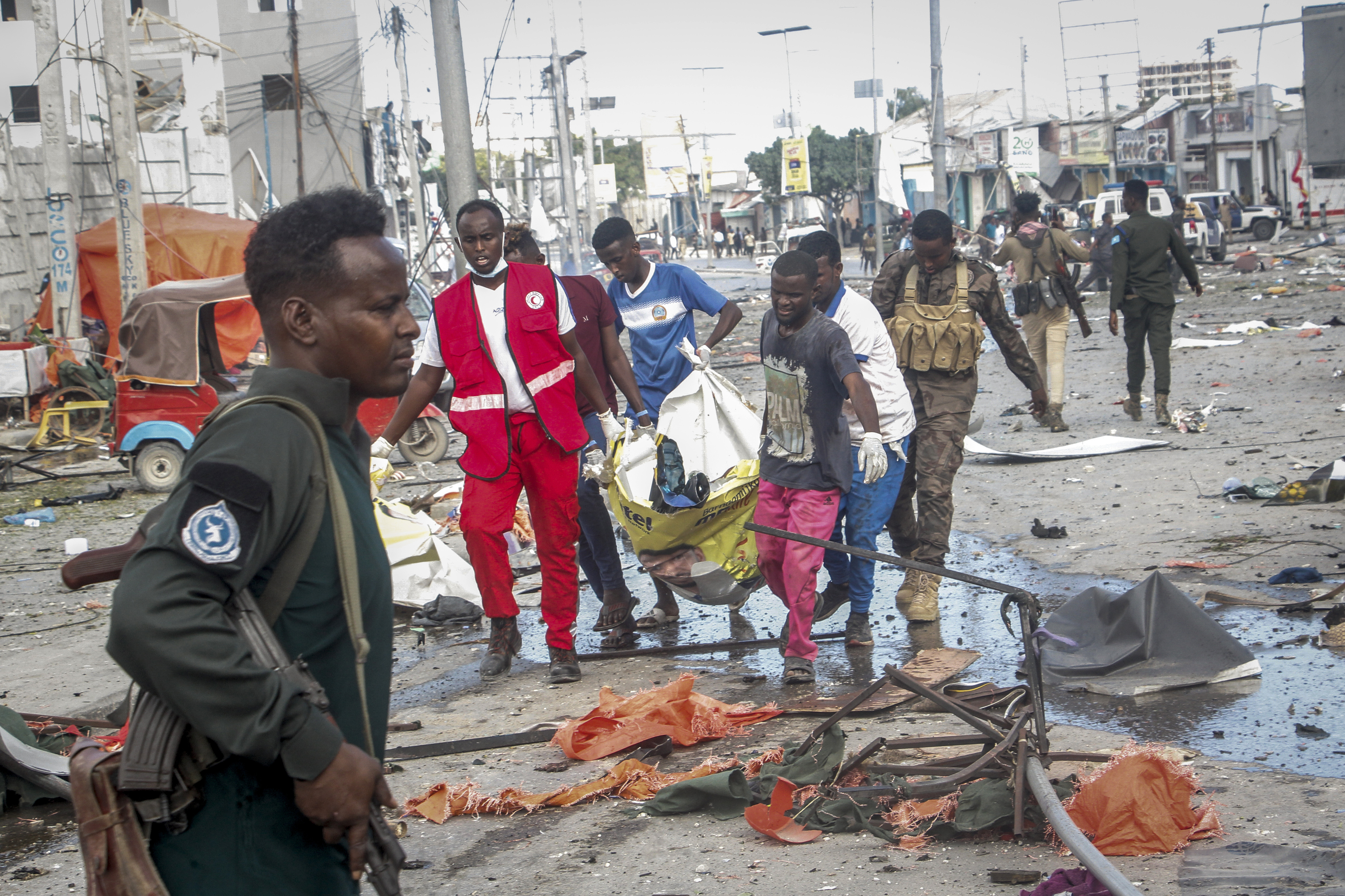 Rescuers remove a body from the scene of a double car-bomb attack in Mogadishu, Somalia, Saturday
