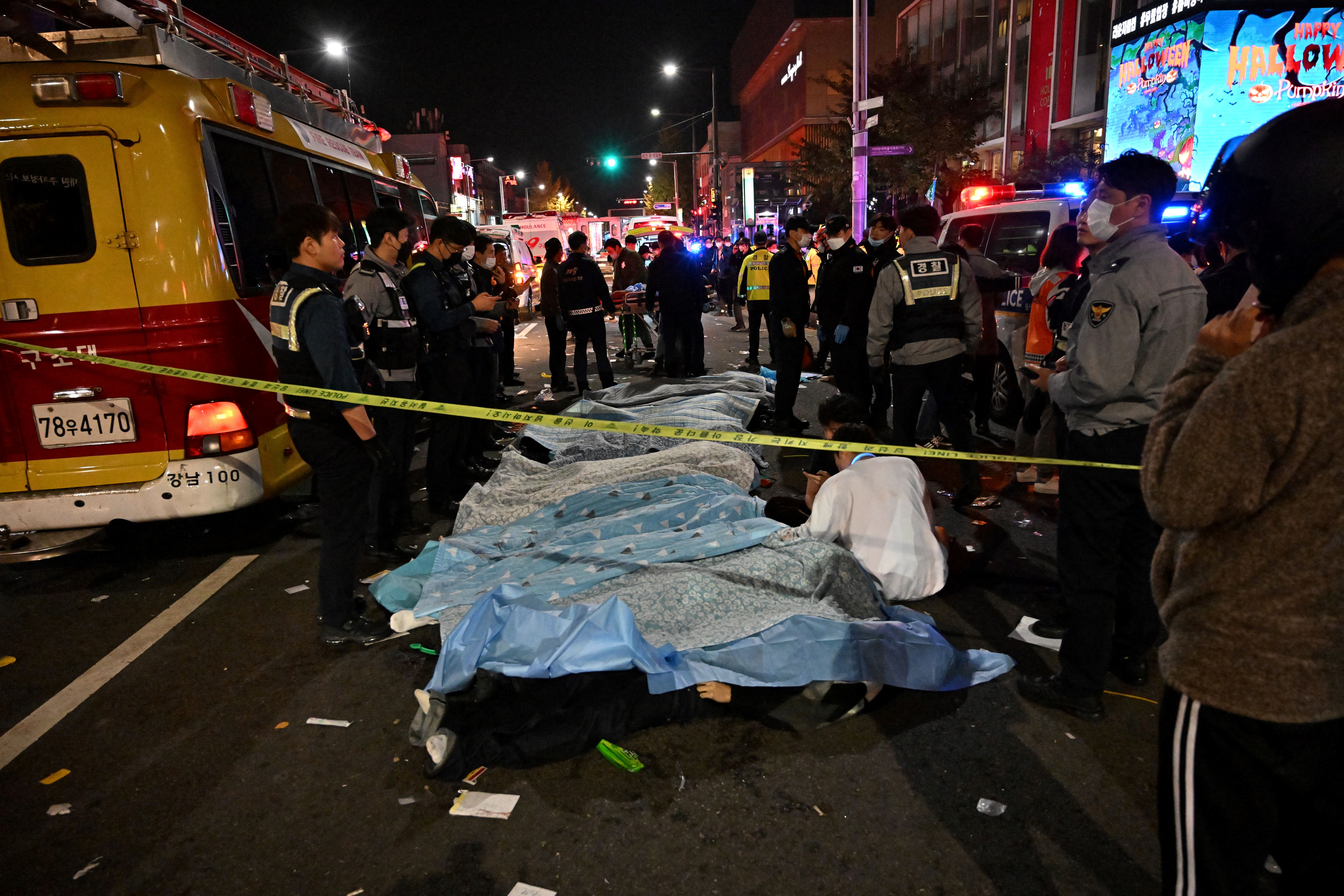 The bodies of victims of the crowd crush are lined up and covered in plastic in the popular nightlife district of Itaewon on Saturday