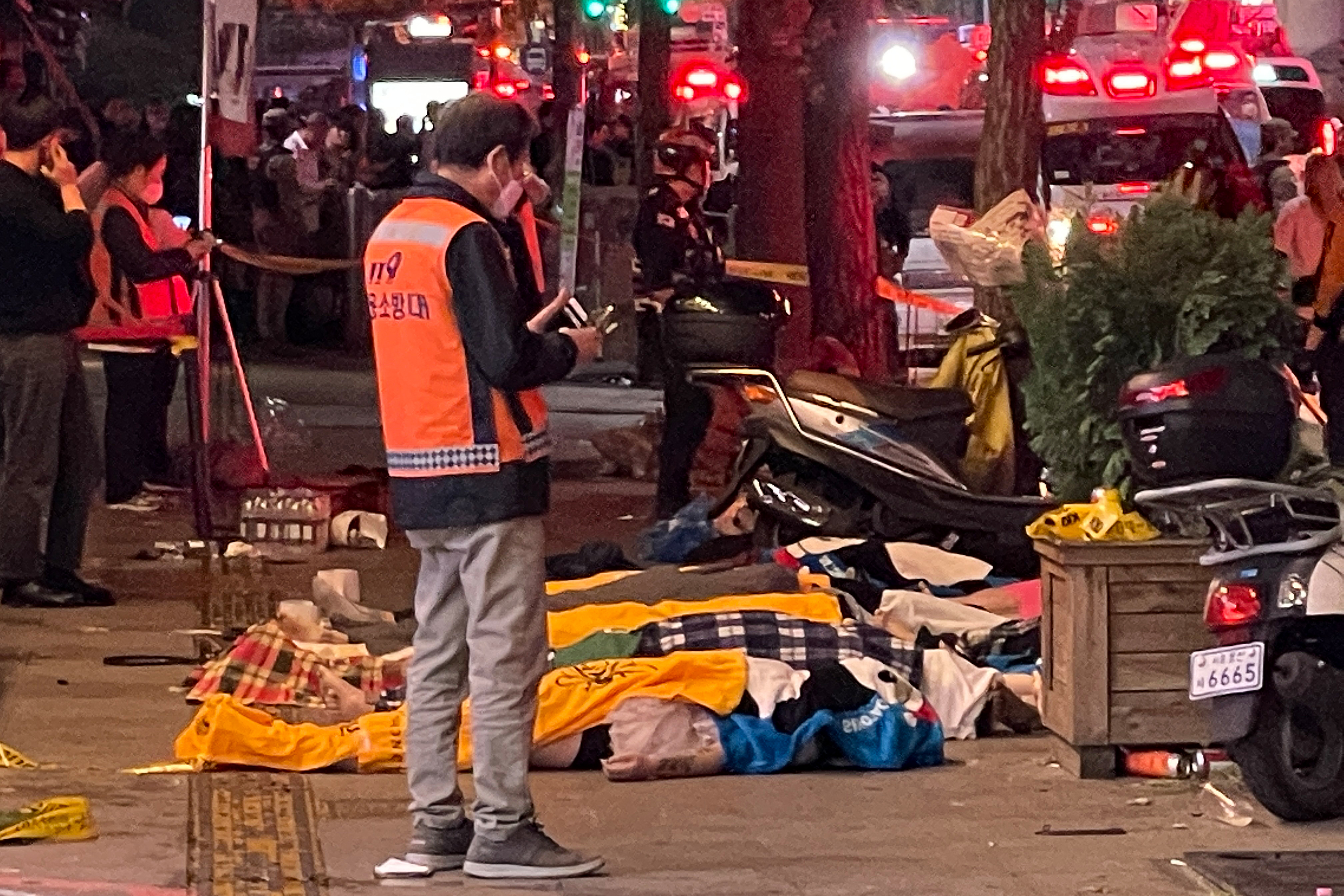 Bodies of victims, believed to have suffered cardiac arrest, are covered with blankets in the popular nightlife district of Itaewon in Seoul on October 30, 2022.