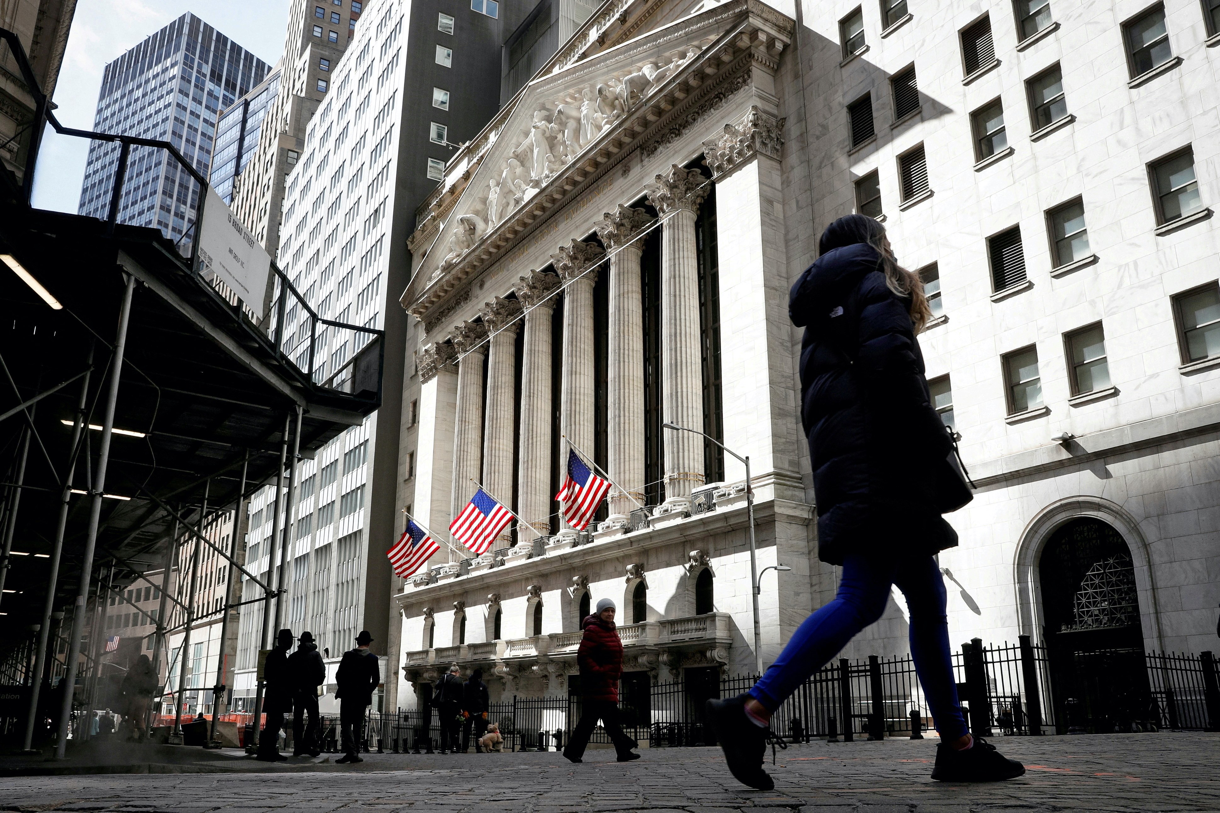 People are seen on Wall Street outside the New York Stock Exchange (NYSE) in New York City, U.S