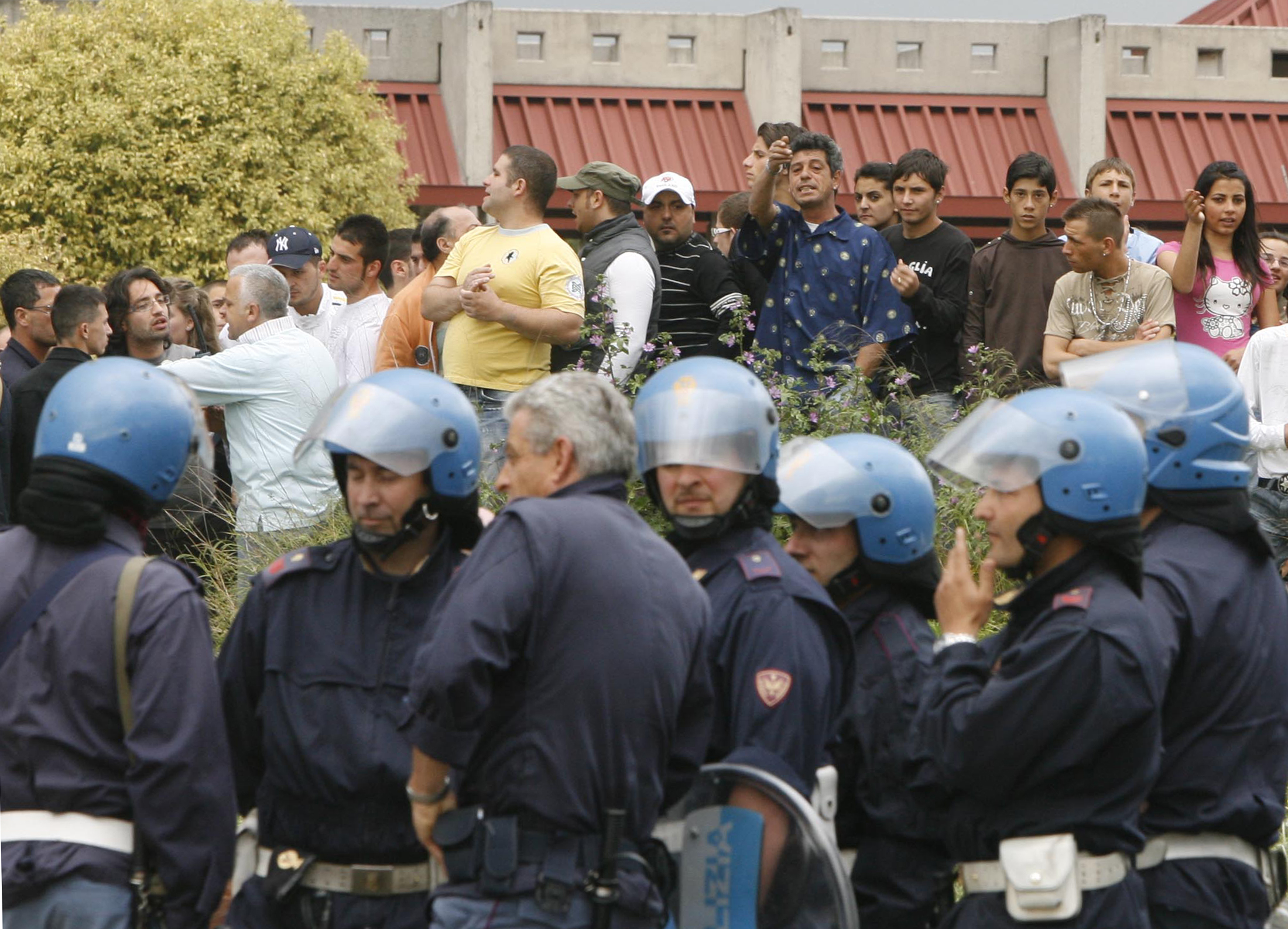 Italian police block locals from entering a Roma camp in a suburb of Naples May 13, 2008. While Romania warned of an outbreak of xenophobia against its people in Italy, locals set fire to two Roma camps in Naples -- previously evacuated by police -- after a 17-year old Roma girl was accused of trying to kidnap an Italian baby. Picture taken May 13, 2008. REUTERS/Ciro De Luca/Agnfoto (ITALY)