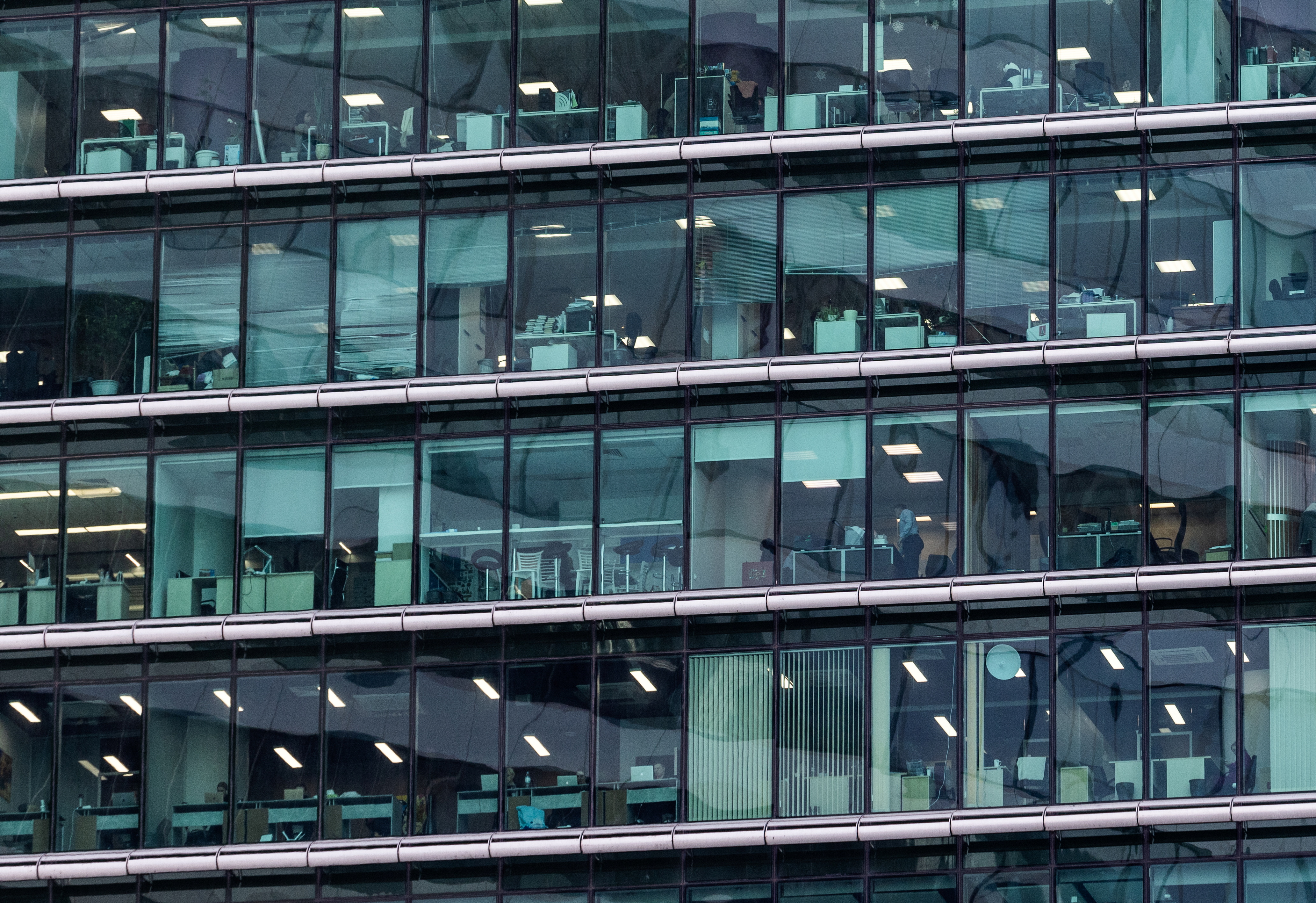 People are seen through windows of an office building in the Moscow International Business Centre