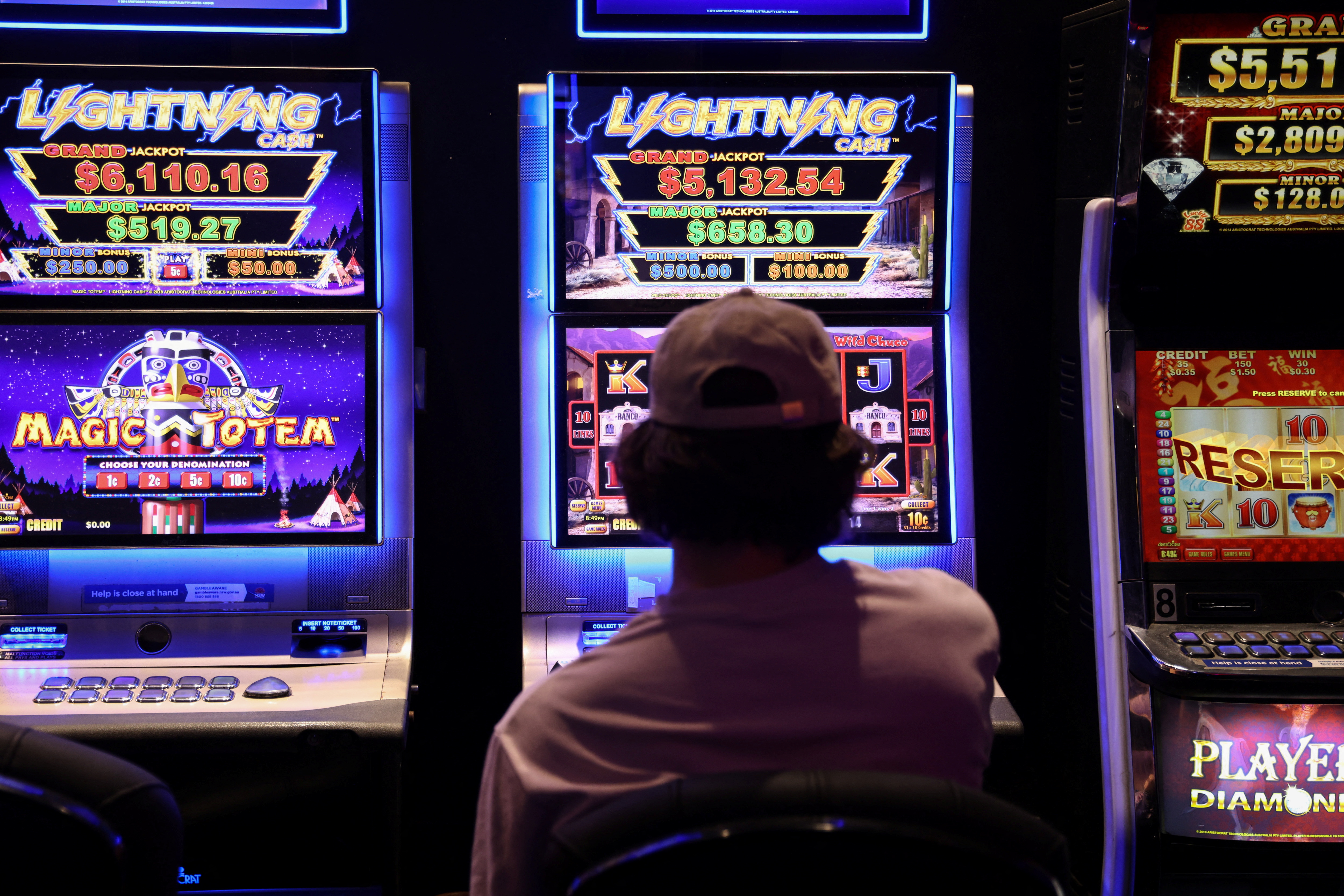Back of man playing on slot machine