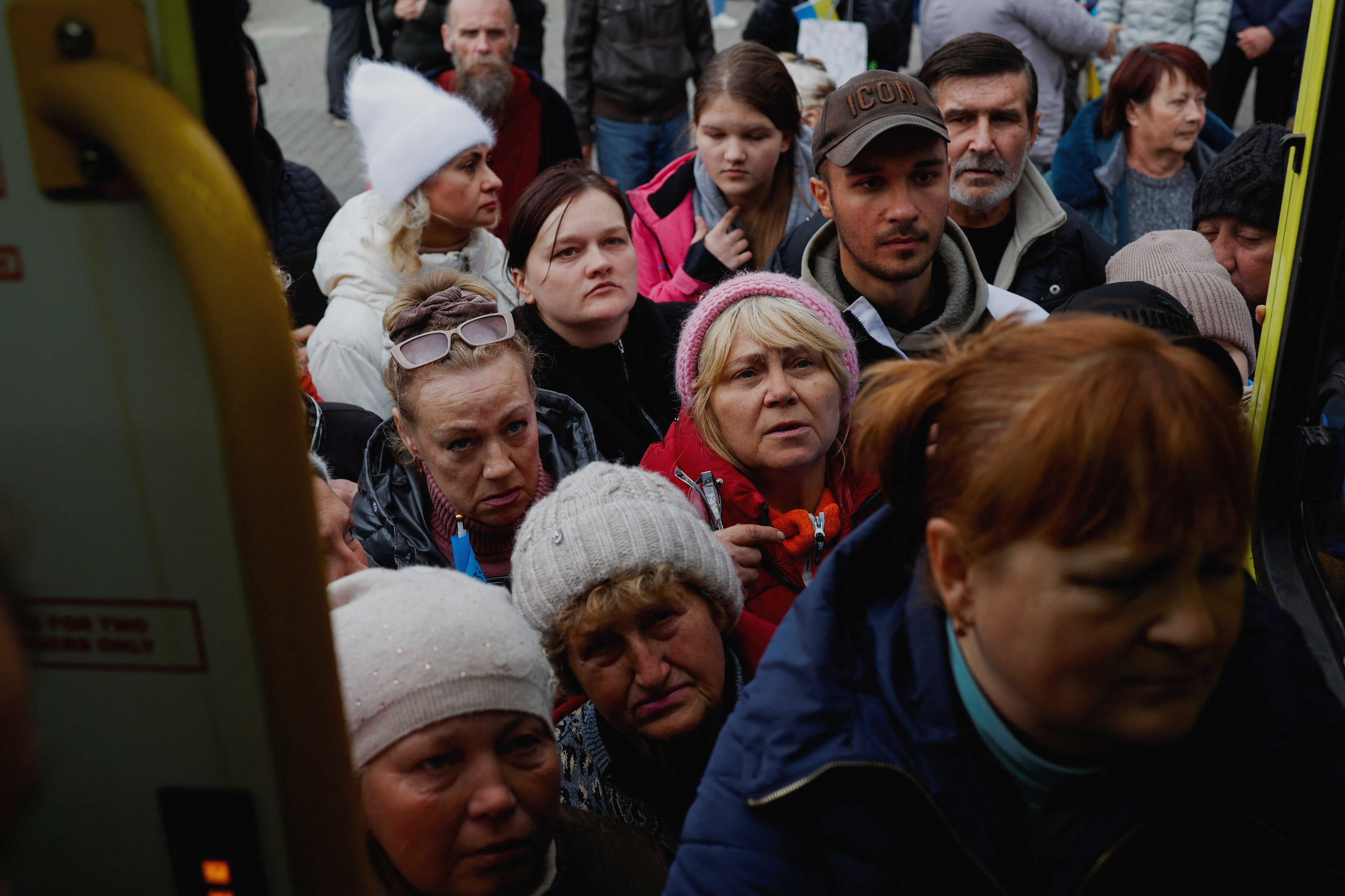 People wait to receive medical aid distributed by international volunteers in central Kherson.