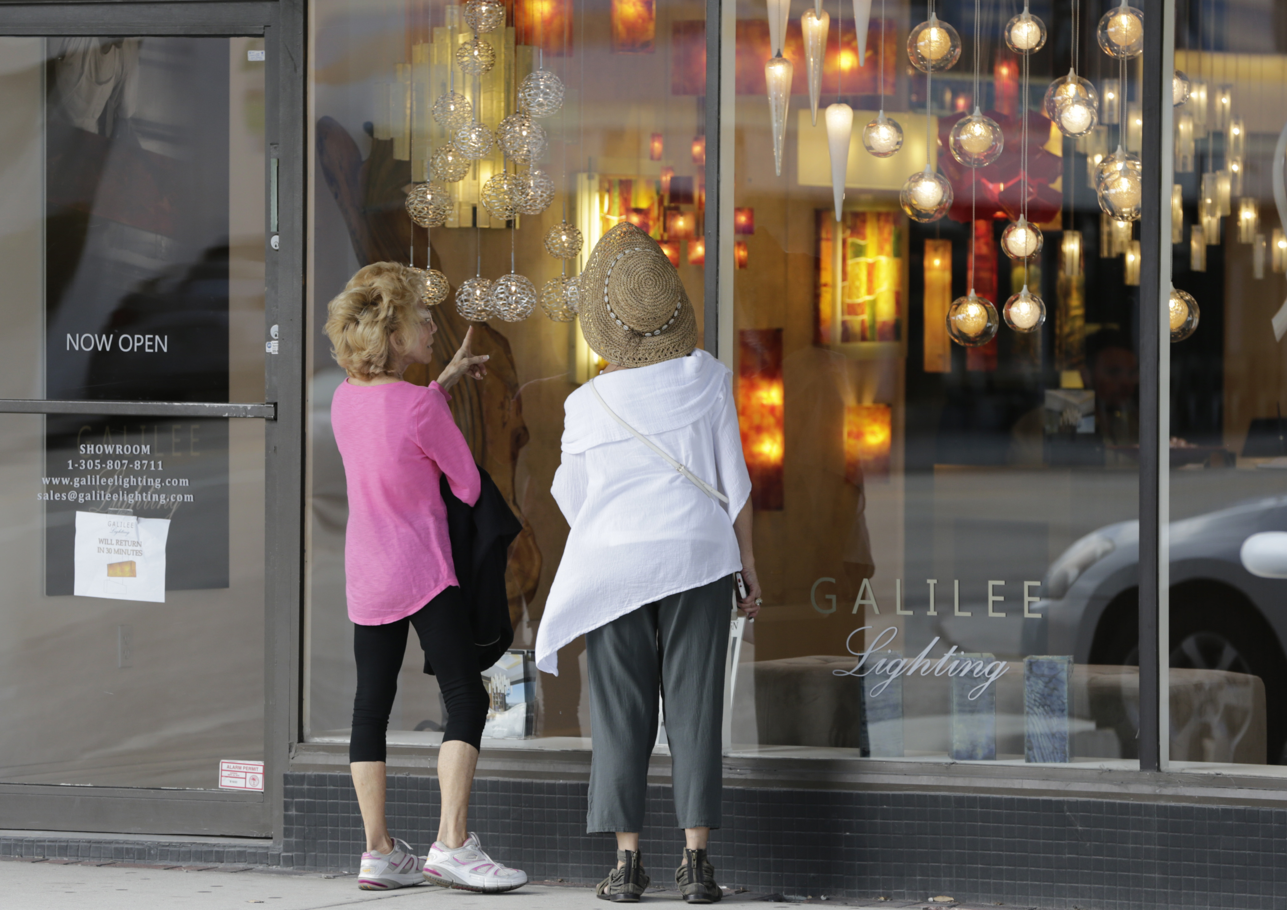shoppers stop to look in the window of a lighting store in the Design District of Miami Beach, Florida in US