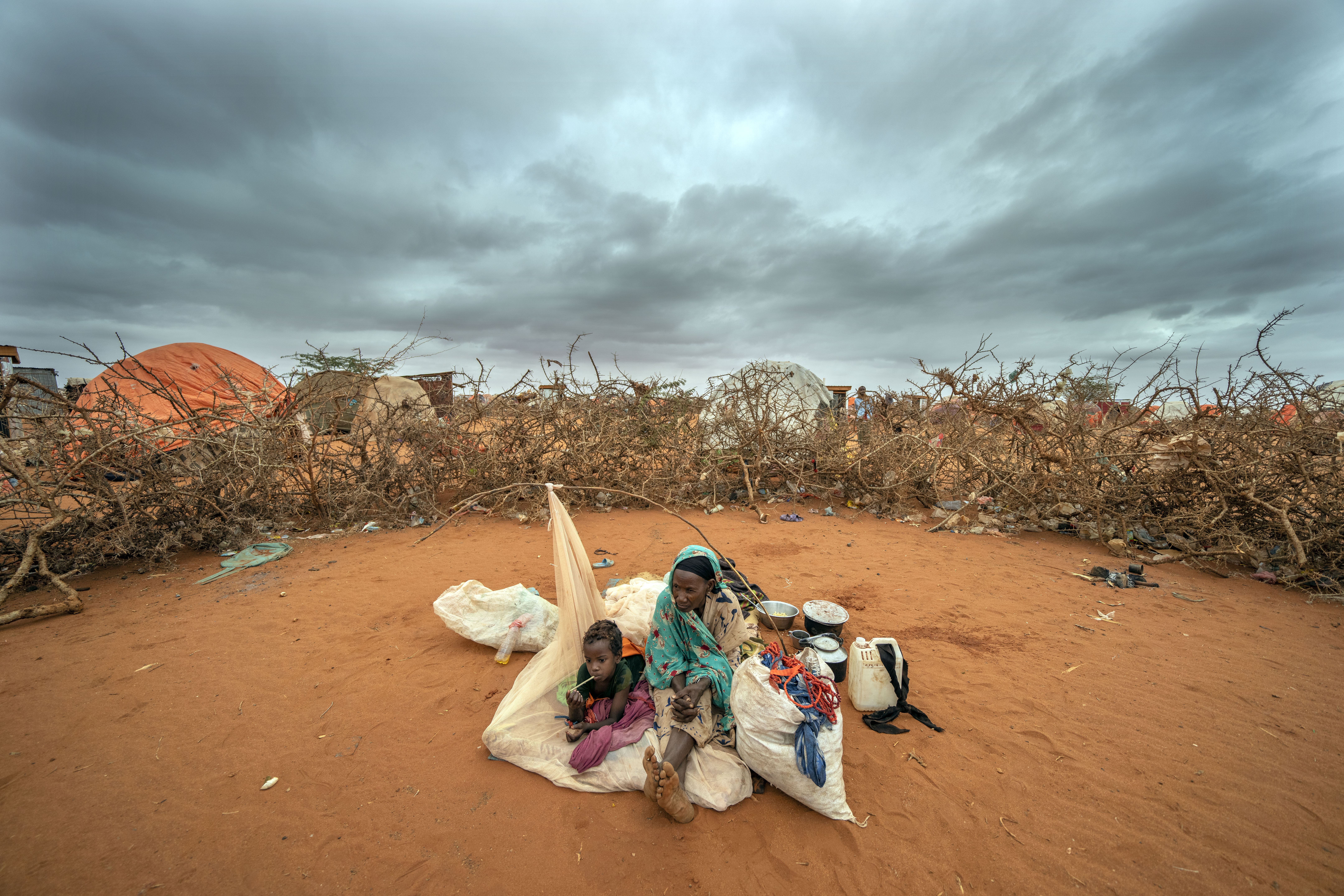 A Somali woman and child wait to be given a spot to settle at a camp for displaced people