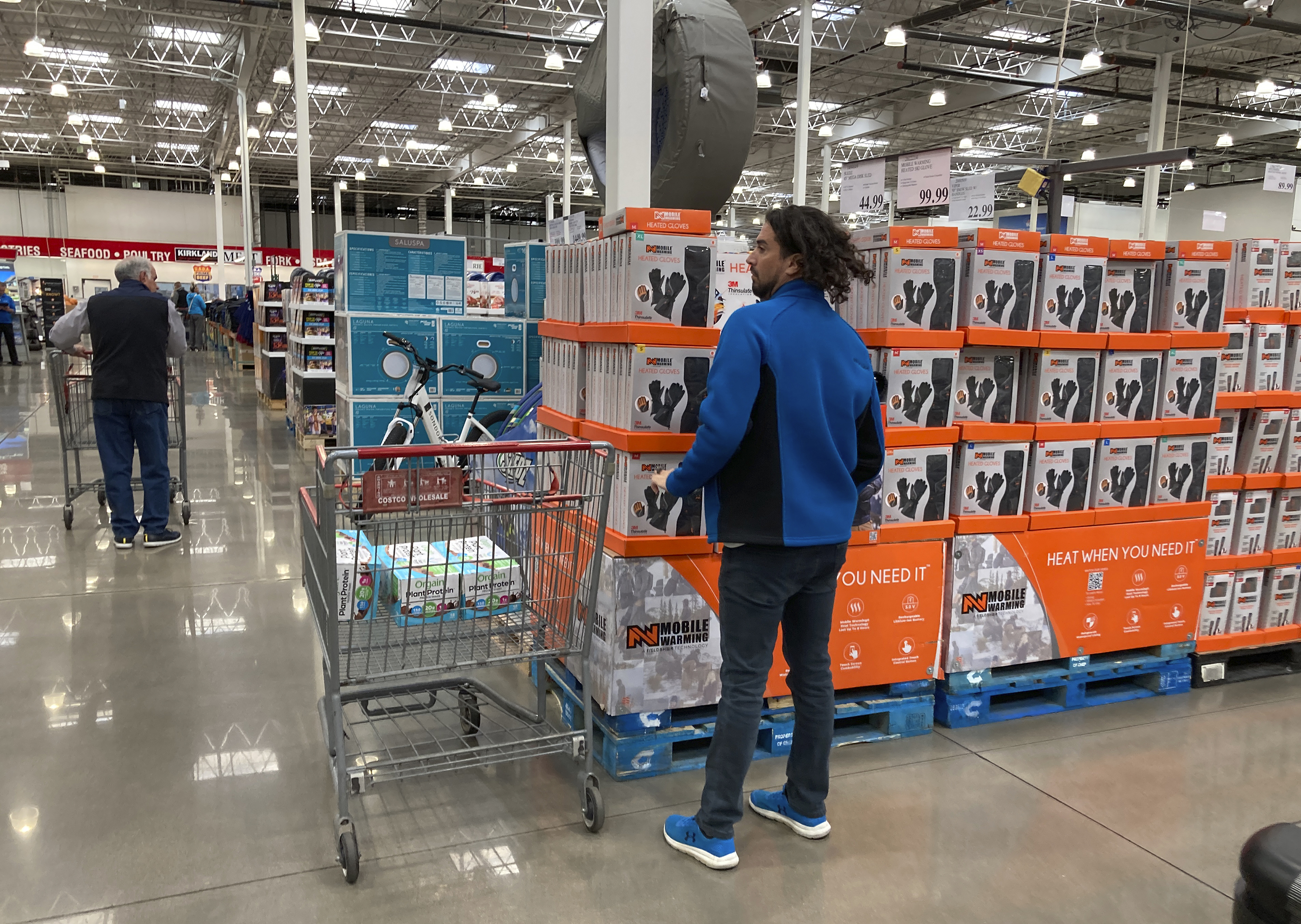 Shoppers ply the aisles of a Costco warehouse, in Sheridan, Colo.