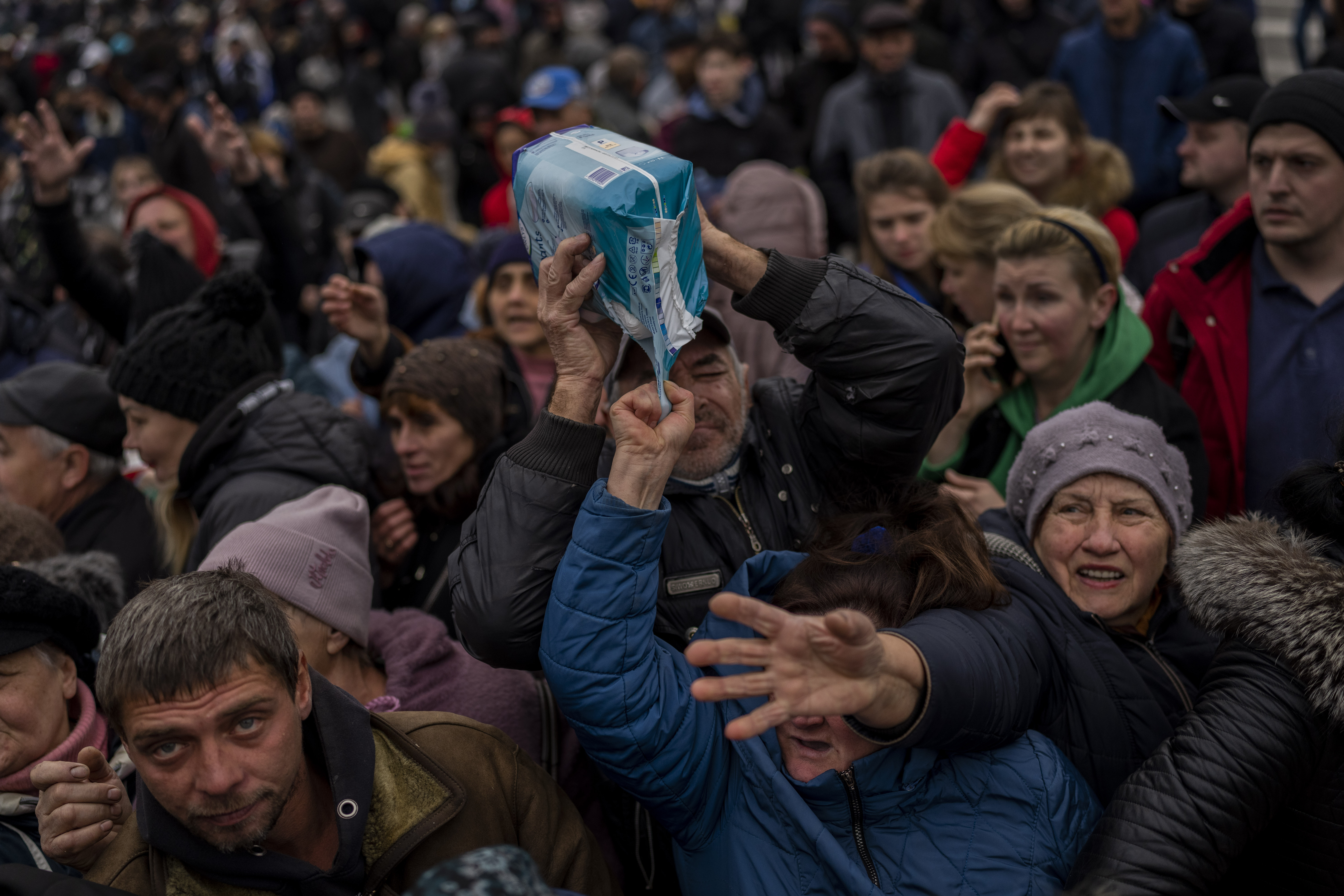 Residents at an aid distribution centre receive supplies in recently retaken Kherson city, southern Ukraine, on Friday