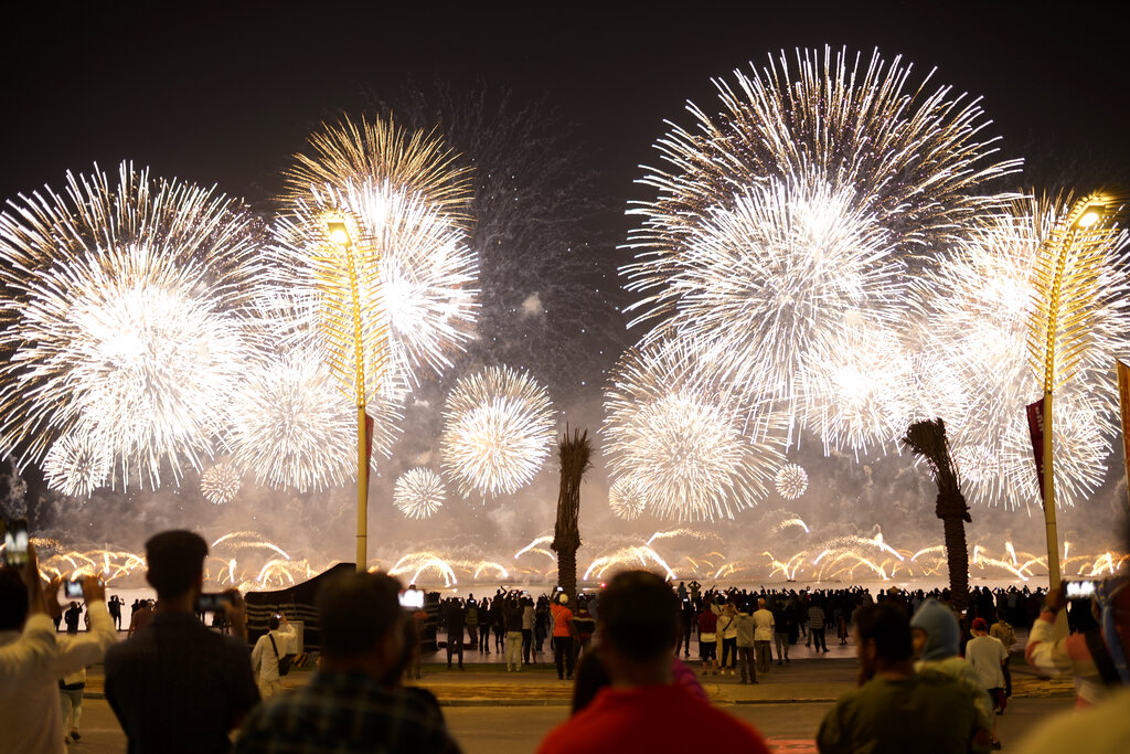 Fans watch a fireworks-filled sky after the World Cup inauguration match between Qatar and Ecuador at the Corniche sea promenade in Doha, Qatar.