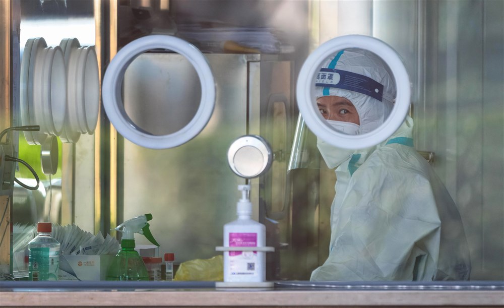 A Chinese medical worker sits in a COVID-19 testing booth at the Disney Resort in Shanghai, China, in November 2022