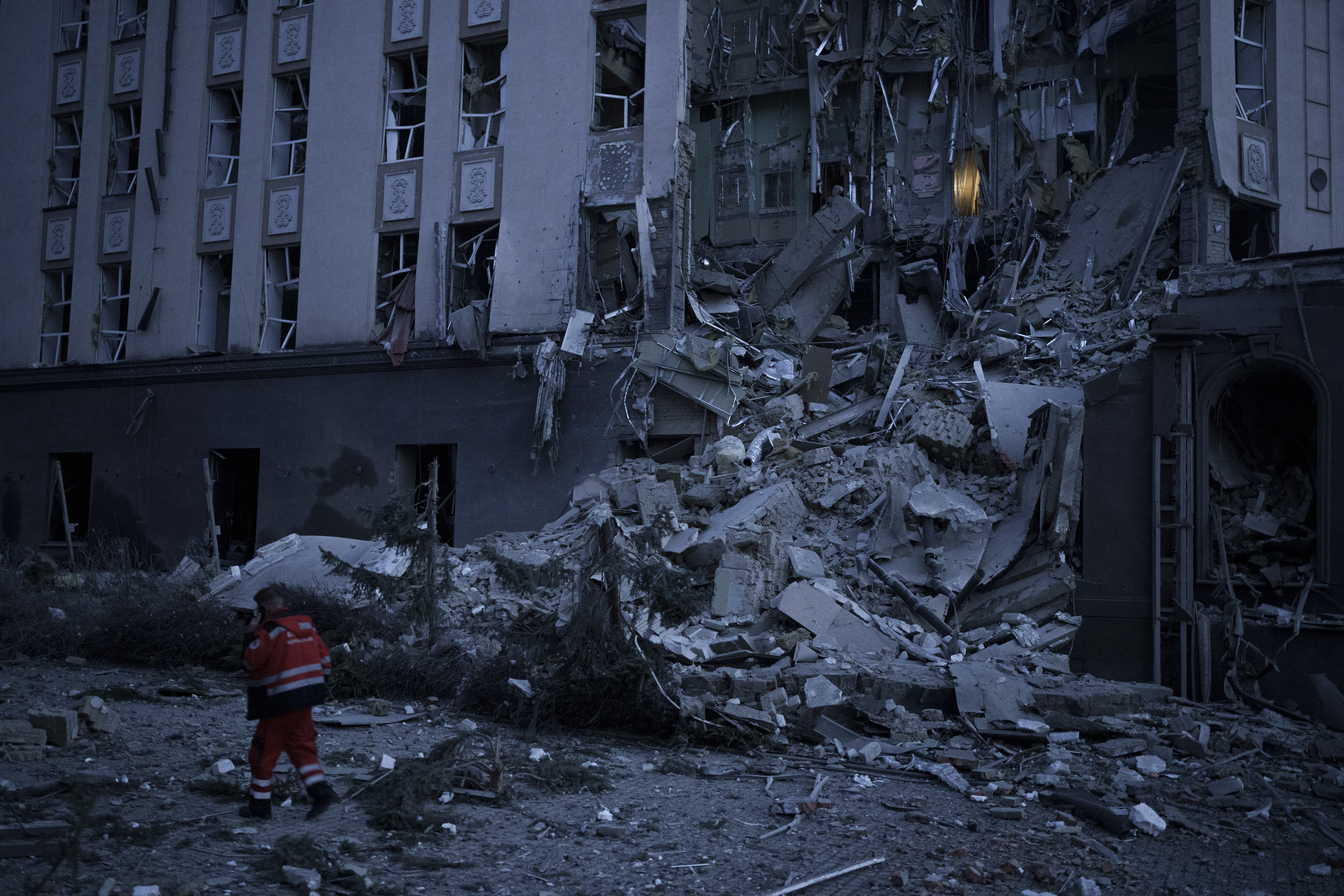 An emergency worker walks in front of a damaged hotel following a Russian attack in Kyiv, Ukraine