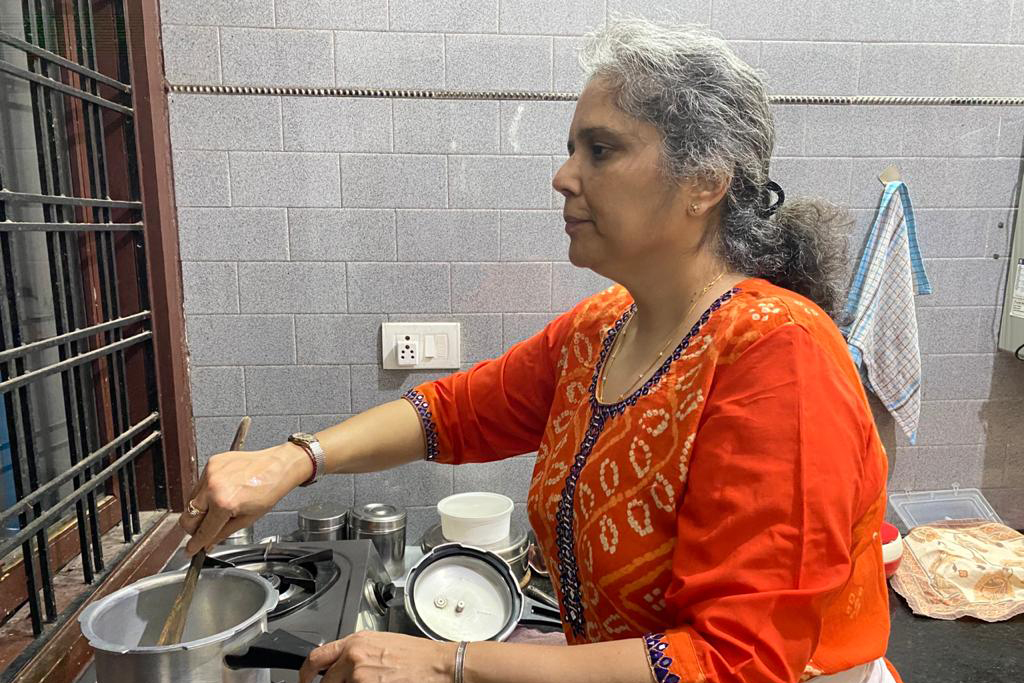 Payal at the stove, cooking by feel because she lost her eyesight