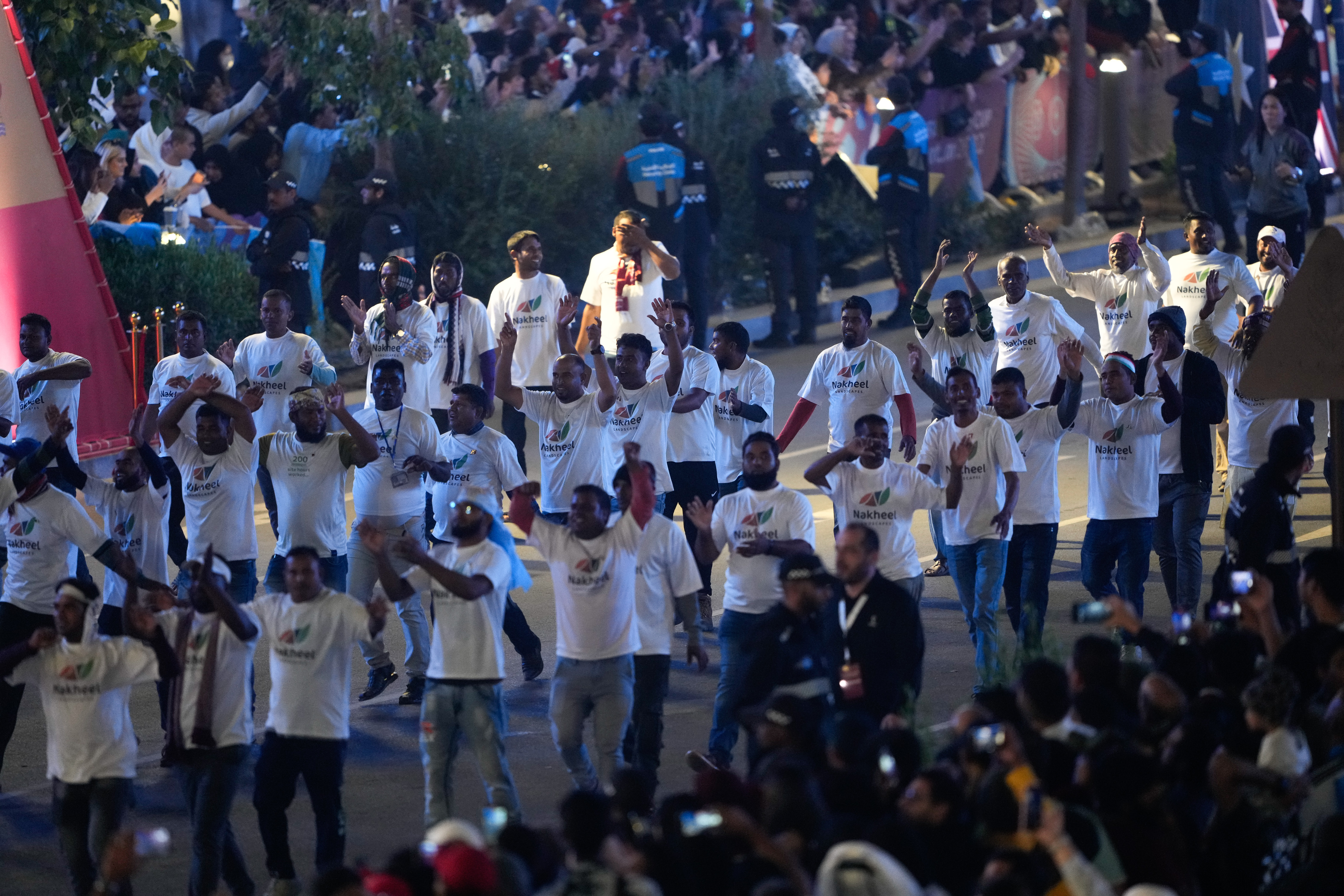 Volunteers walking along Lusail Boulevard during the parade.