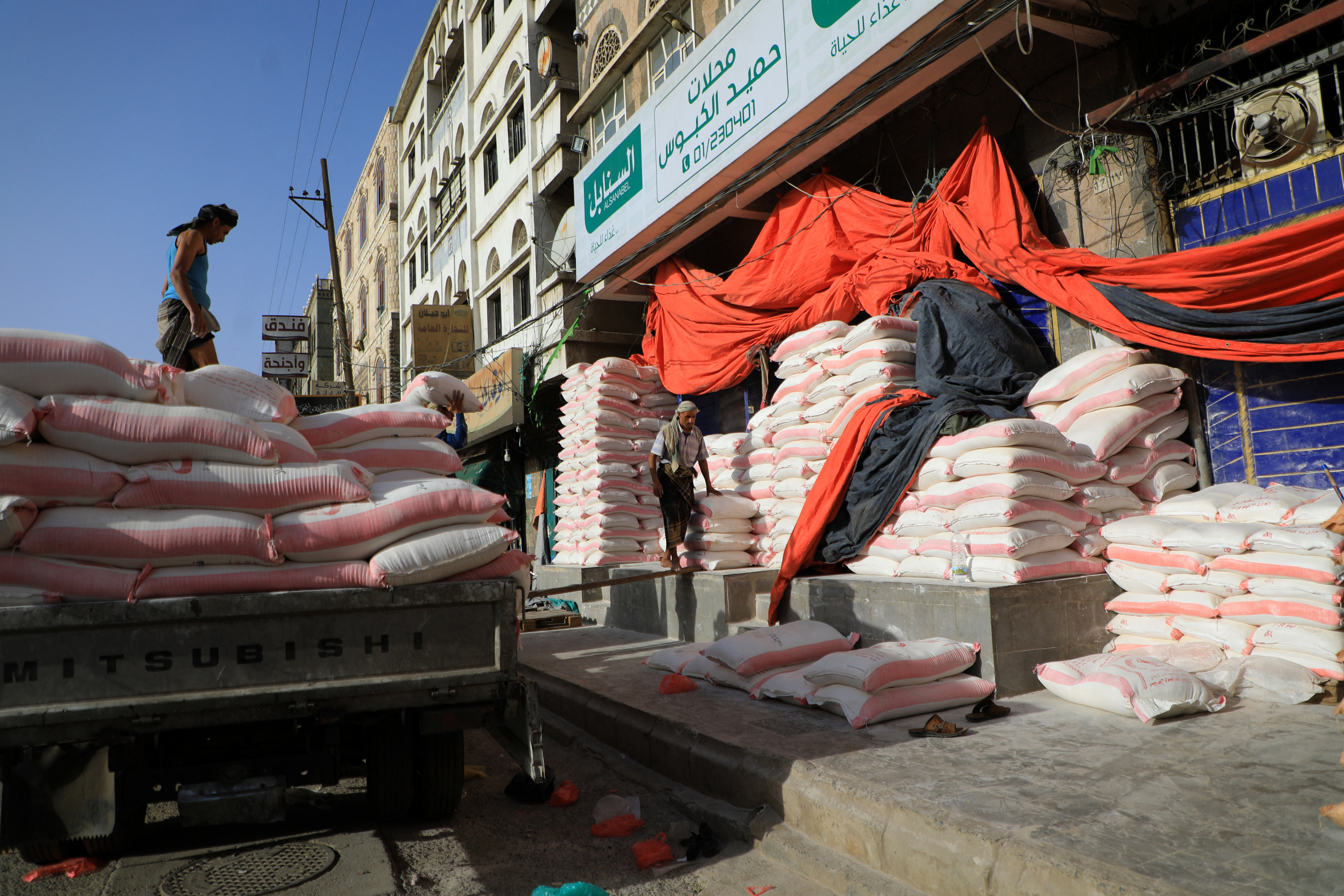 A photo of a market with sacks of flour all around the outside of a building.