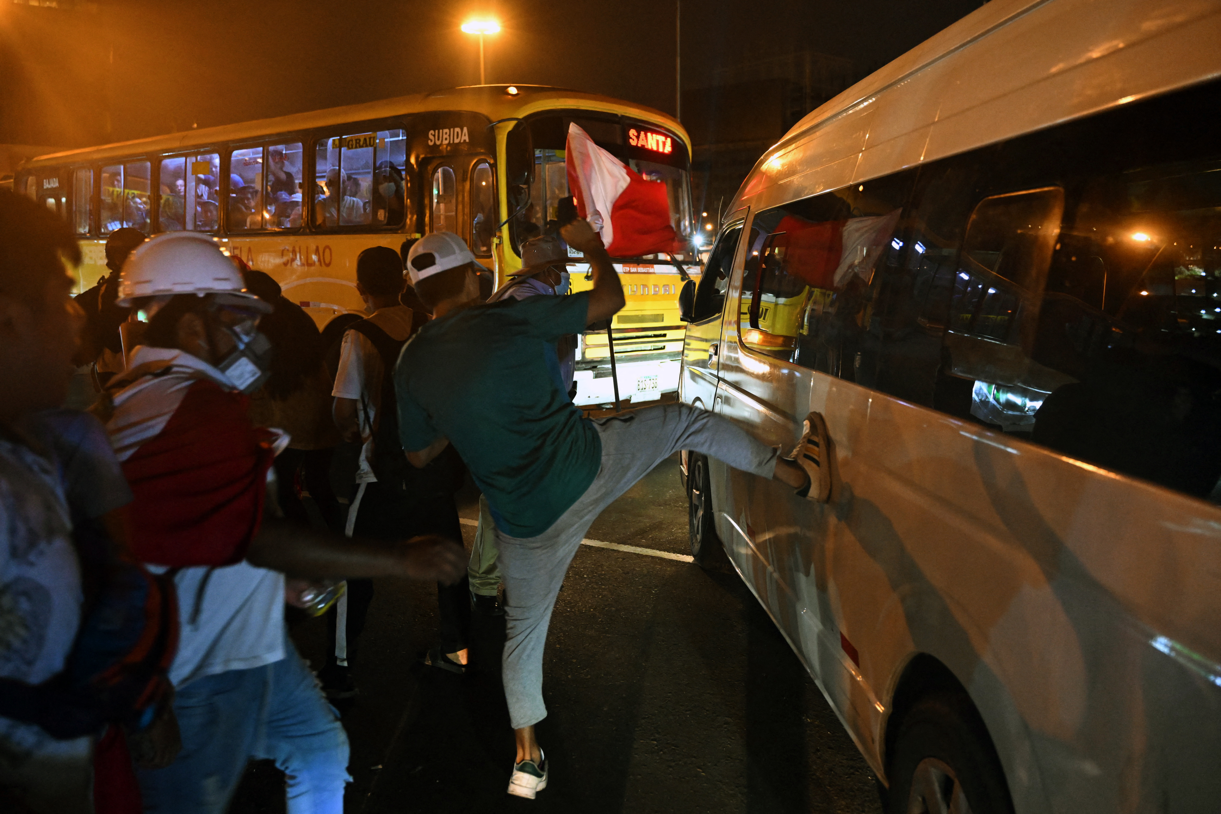 Demonstrators attack vehicles in traffic during a protest demanding the resignation of Peru's President Dina Boluarte in Lima on January 23, 2023. - Civil unrest since the ouster of Dina Boluarte's predecessor, Pedro Castillo, in early December has left 46 people dead and prompted the government to impose a state of emergency in violence-hit areas. (Photo by ERNESTO BENAVIDES / AFP)