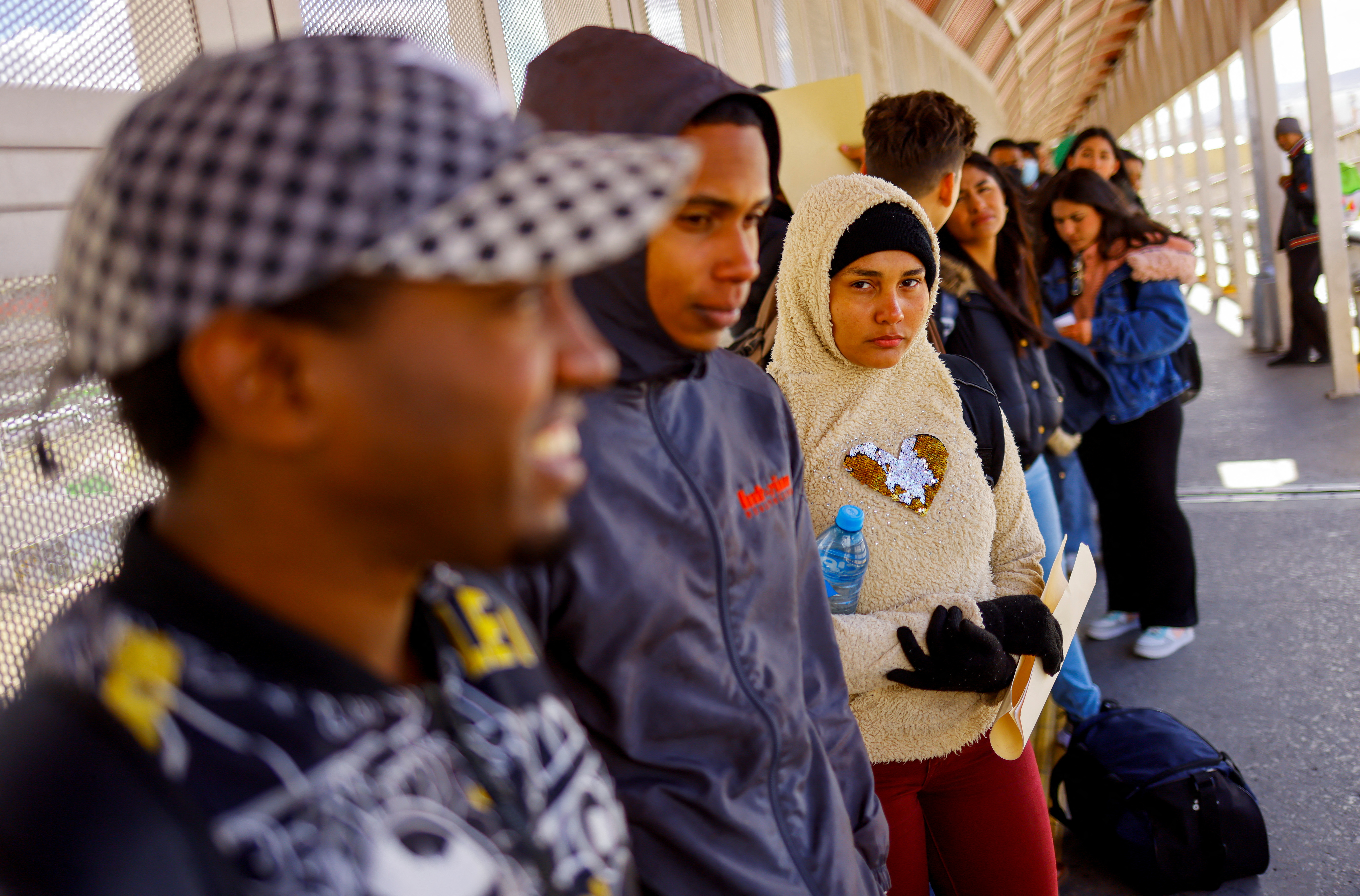 Asylum seekers stand in line at a border crossing in Ciudad Juarez, Mexico
