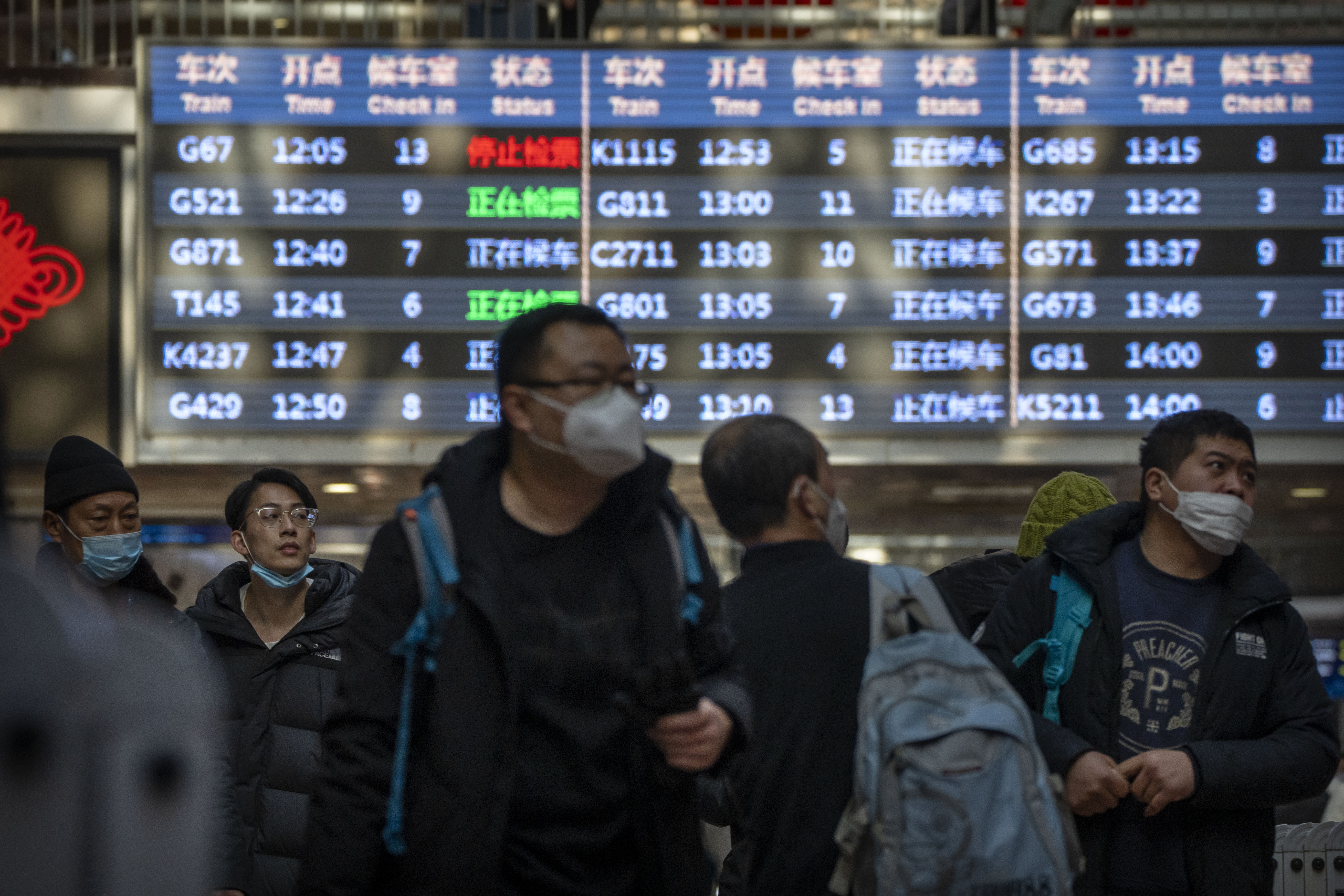 Travelers walk along a concourse at Beijing West Railway Station in Beijing