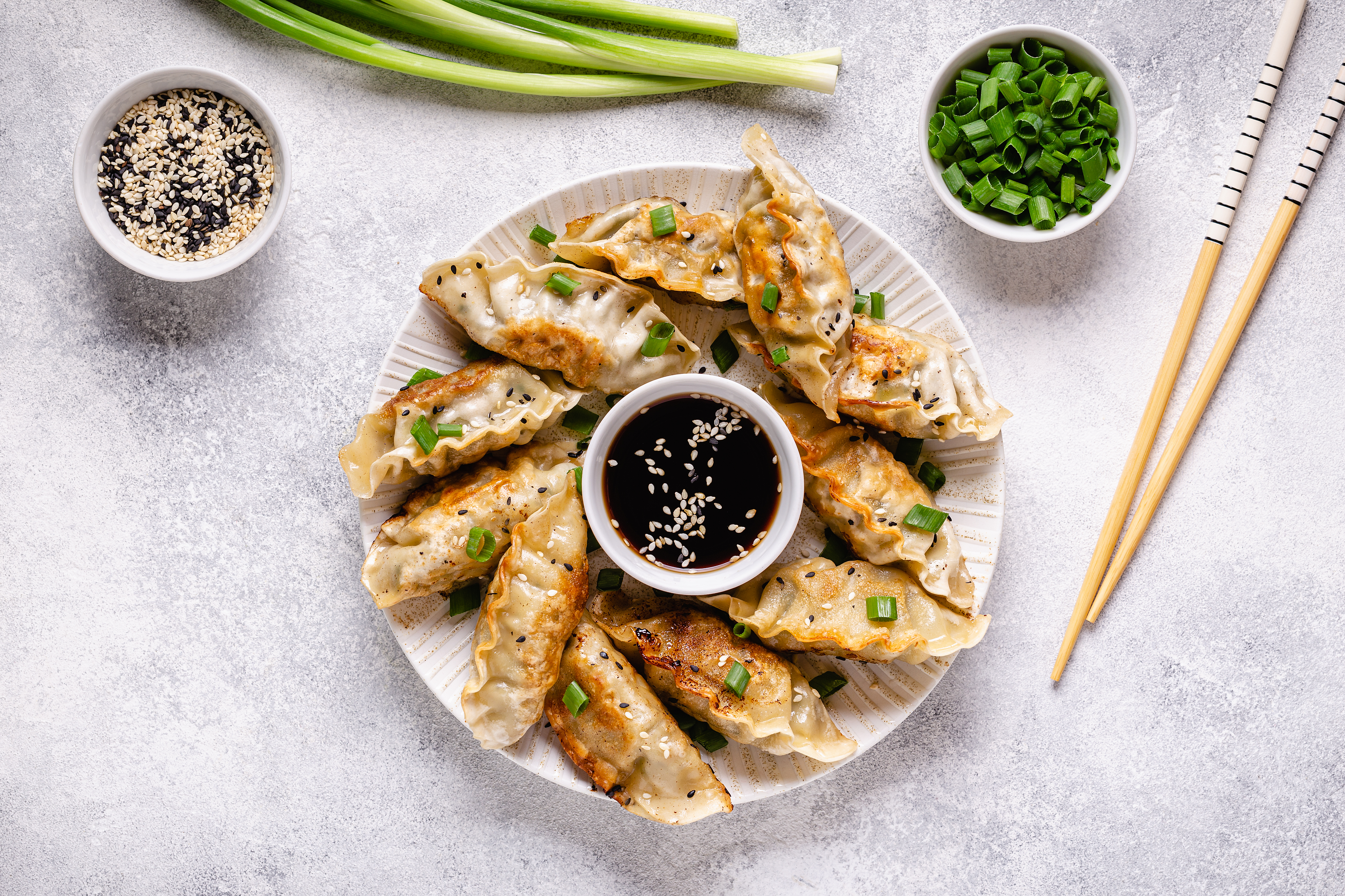 photo of a platter of dumplings with a bowl of sauce in the center