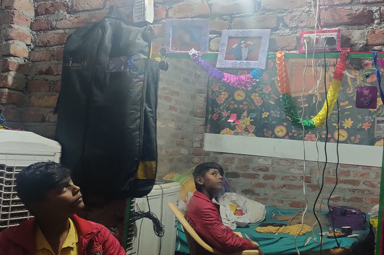A photo of a child looking into a mirror up at a framed photo of someone.