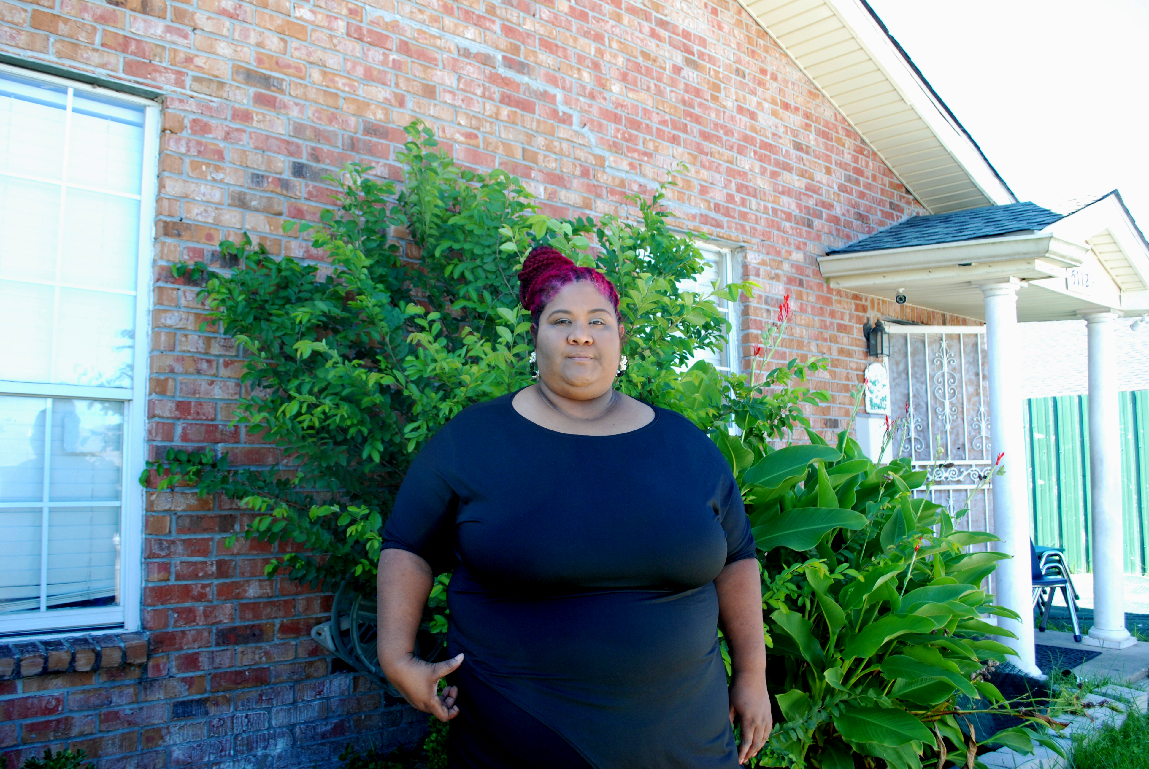 A zoomed out photo of Cristi Fajardo in front of a building.