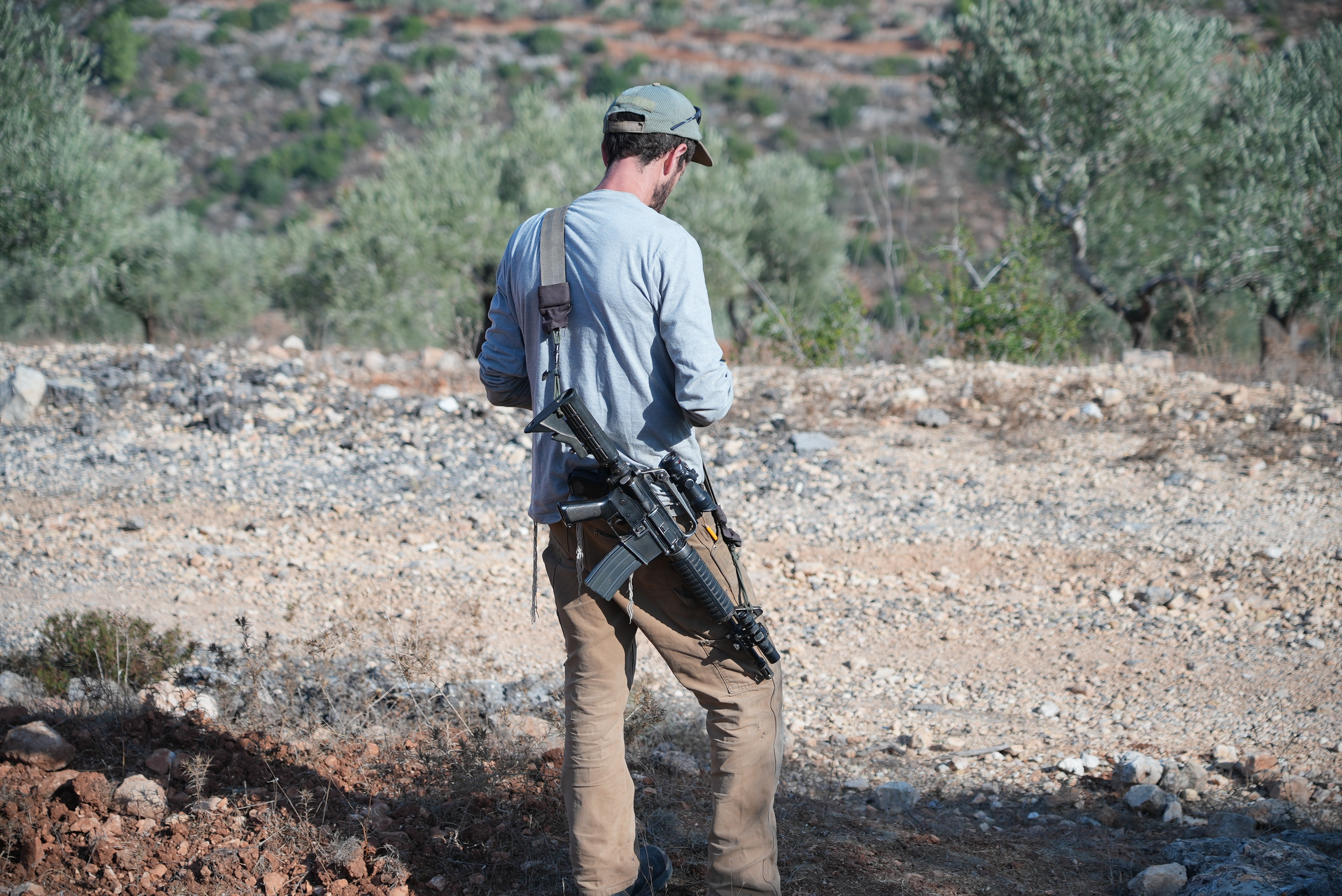 An armed settler is seen in Jibiya's forest