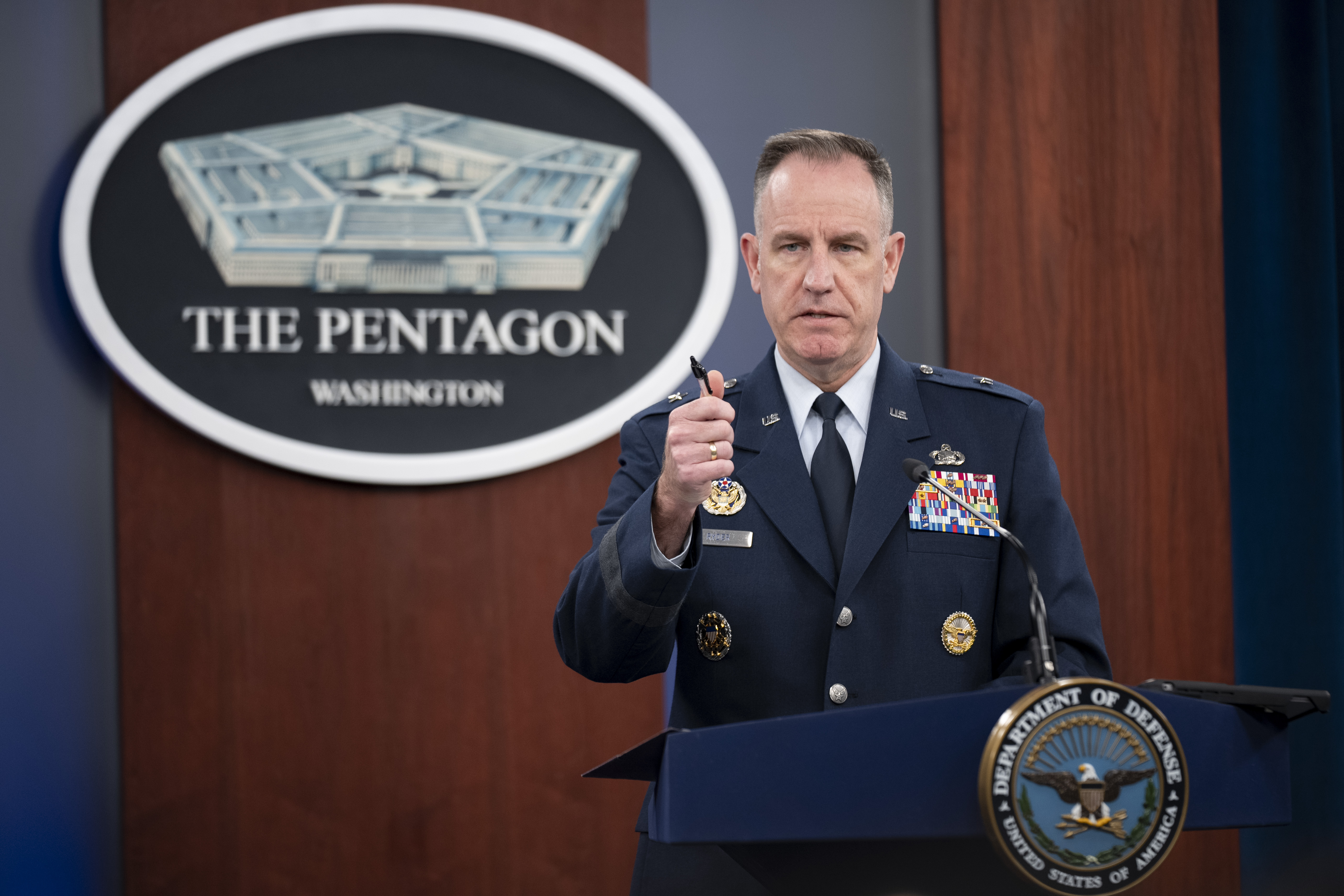 Patrick Ryder at a Pentagon press conference, gesturing from the podium