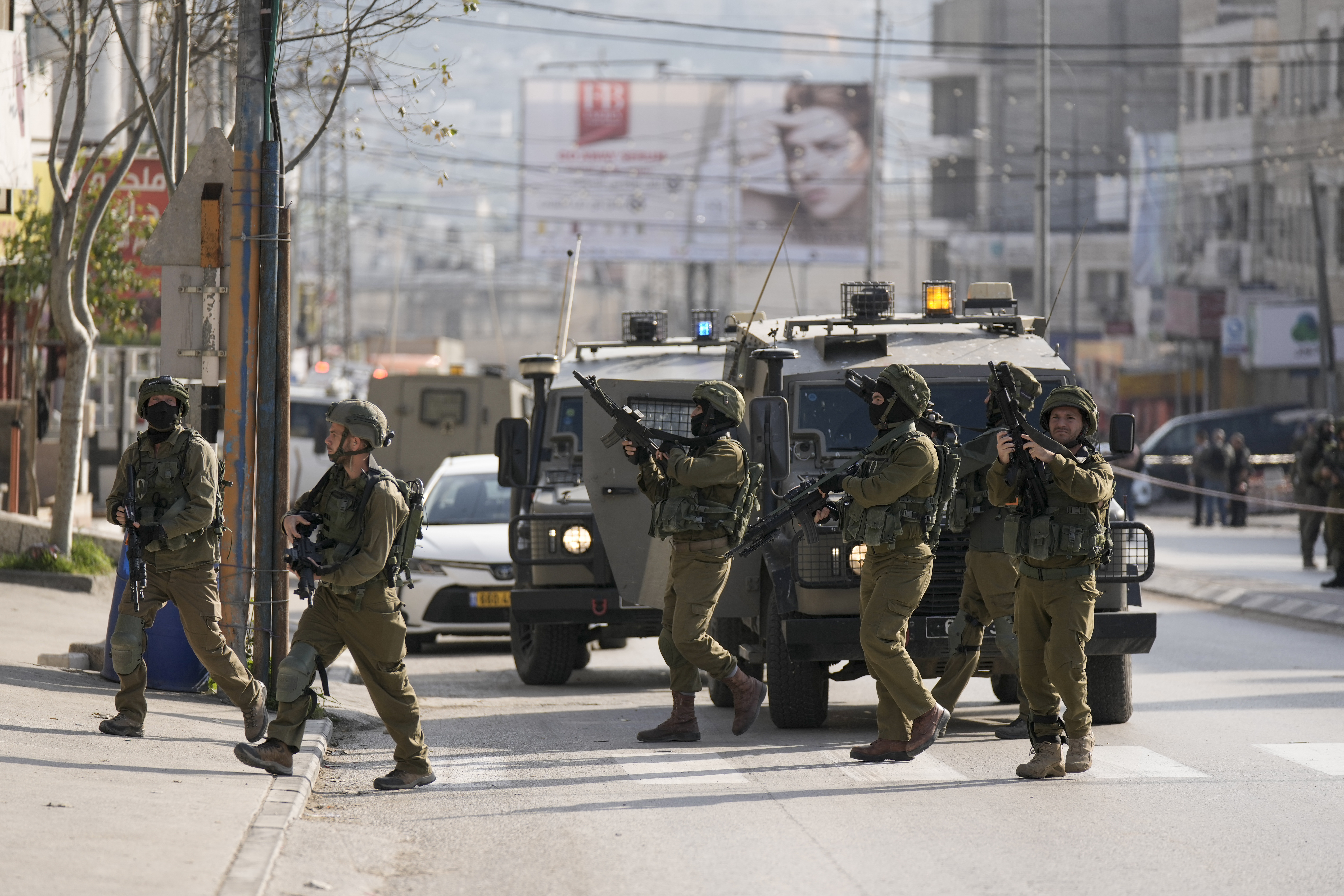 Israeli soldiers take up positions at the scene of a Palestinian shooting attack at the Hawara checkpoint near the occupied West Bank city of Nablus.