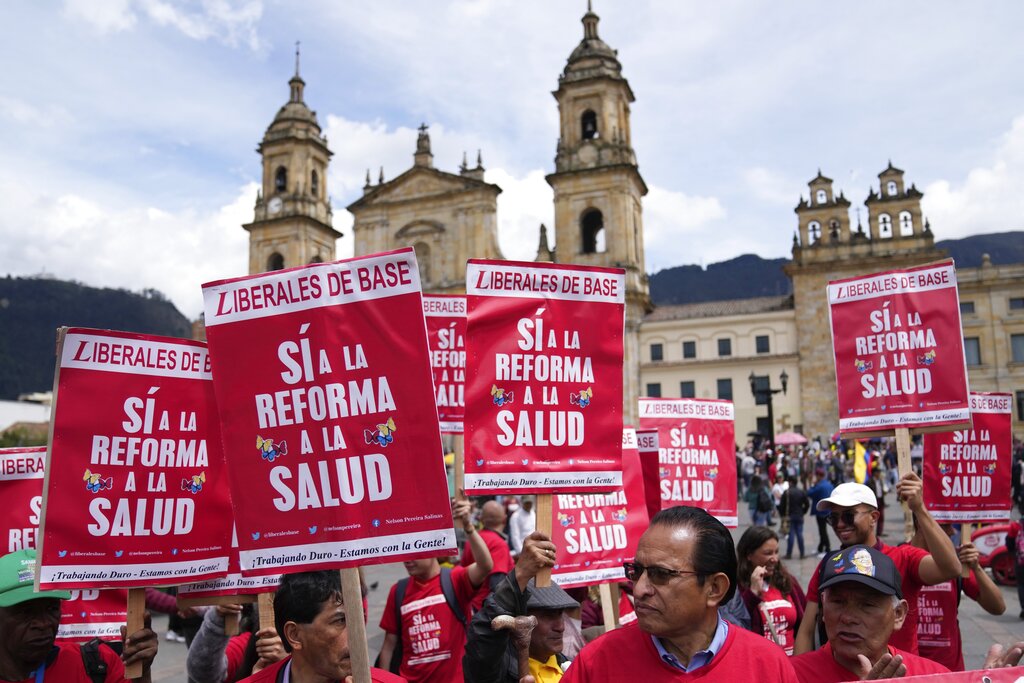 Protesters hold red signs