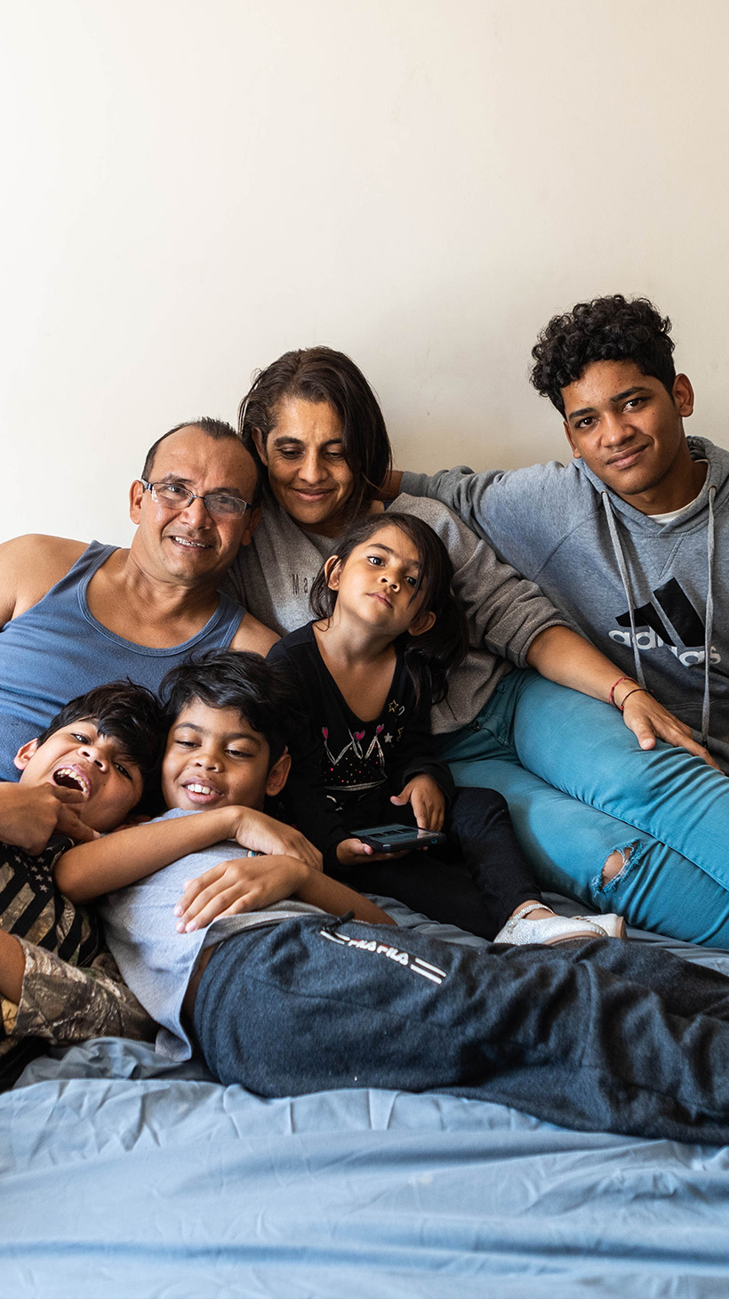 Allyson, her parents and three of her siblings pile onto a bed to take a family portrait.