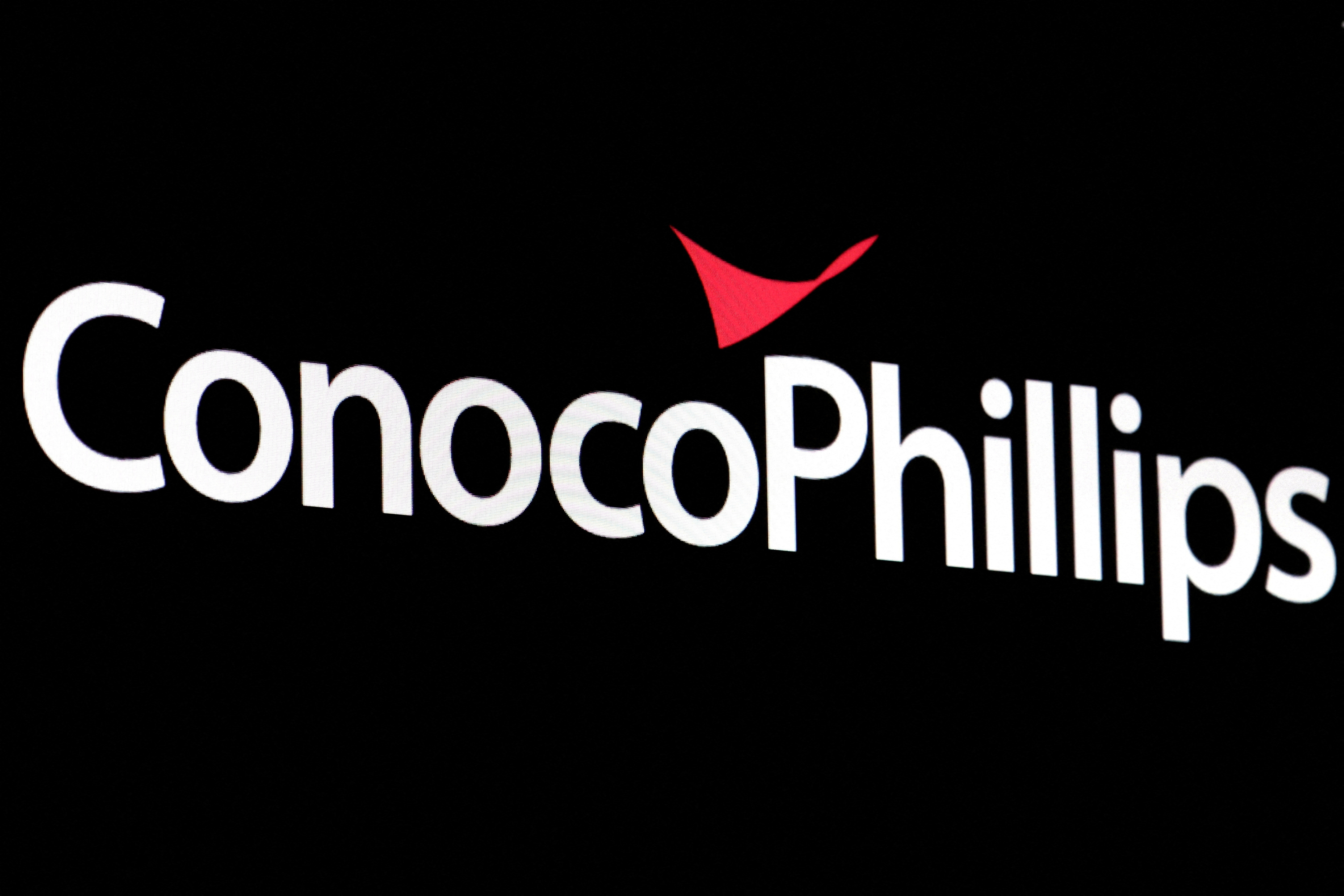 A screen displays the logo for ConocoPhillips on the floor of the New York Stock Exchange