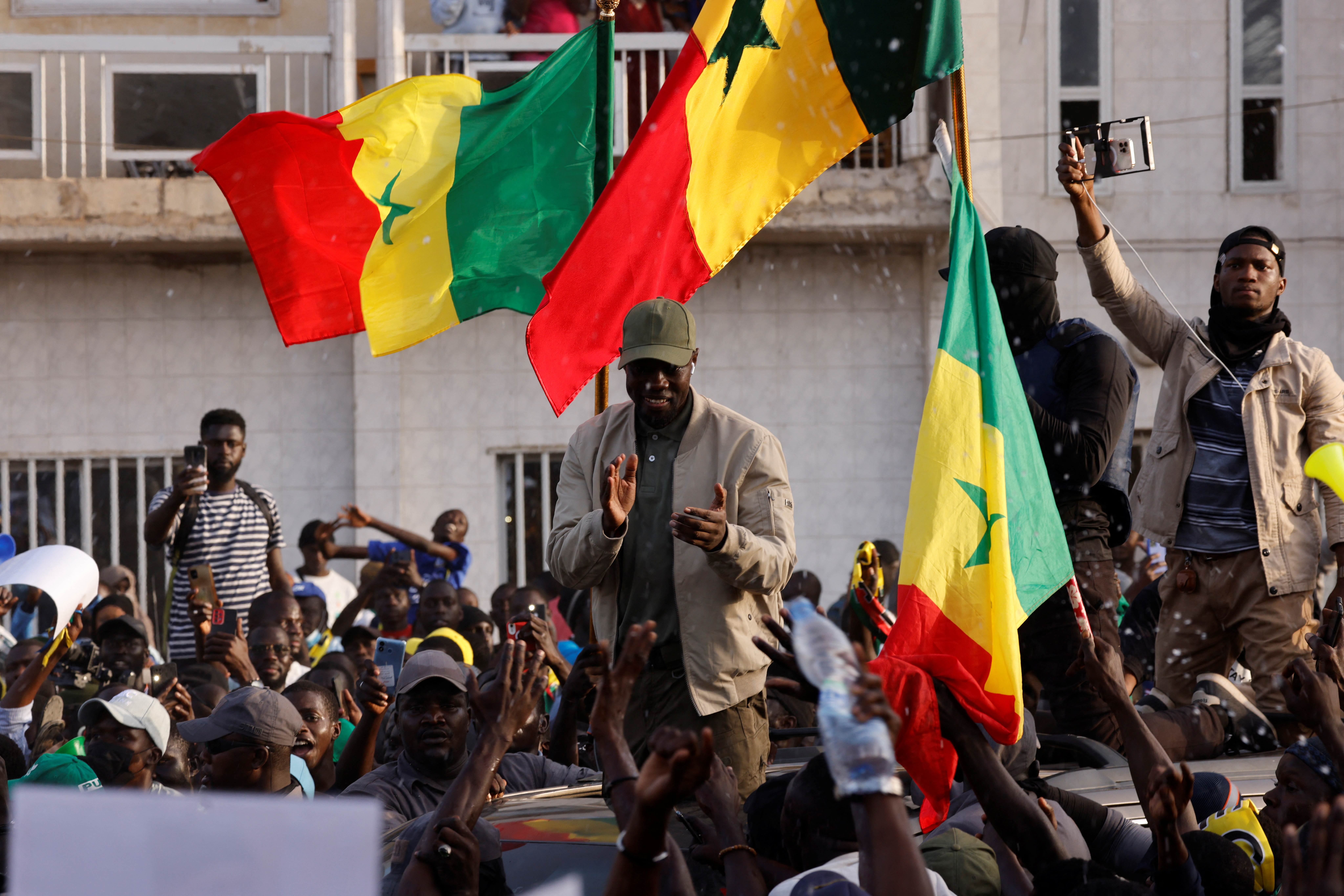 Senegalese opposition leader Ousmane Sonko greets his supporters as he arrives to attend the protest to demand the release of alleged political prisoners ahead of his court appearance on Thursday on libel charges in Dakar