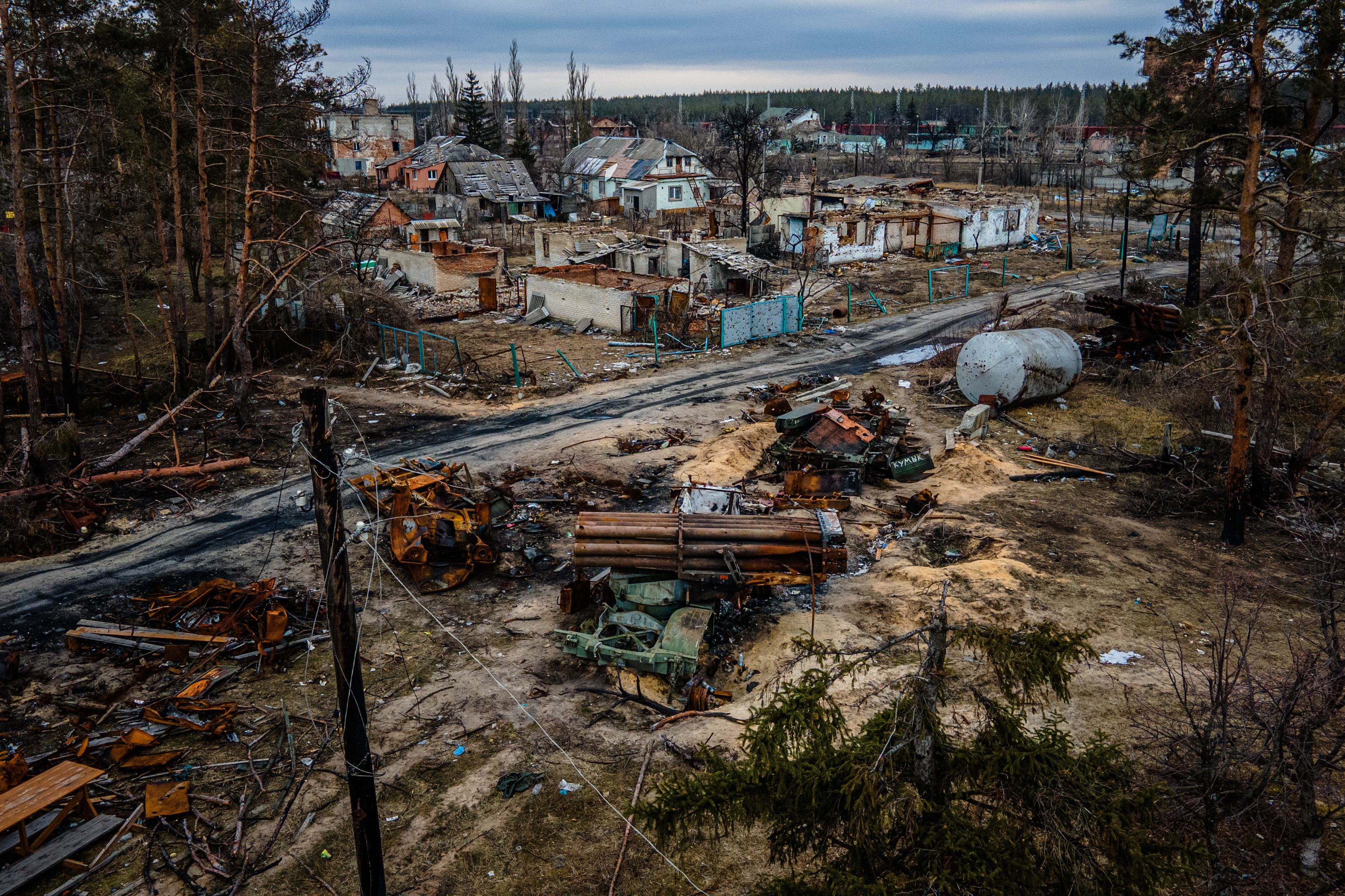 This photograph shows a burned Russian MLRS Uragan and destroyed houses in the village of Sosnove, Donetsk region