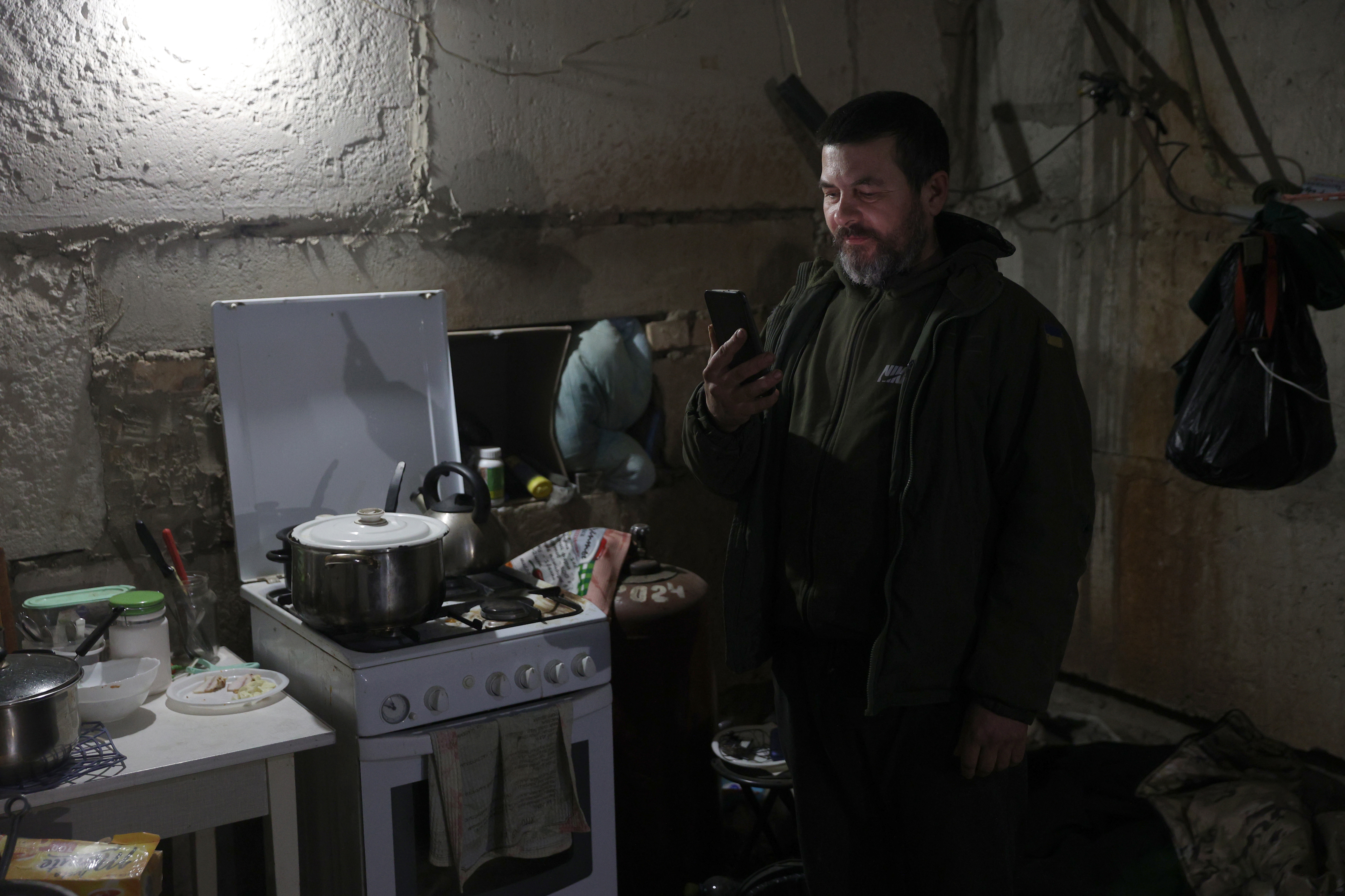 A Ukrainian serviceman speaks with his wife through a smart-phone in a shelter in the town of Bakhmut