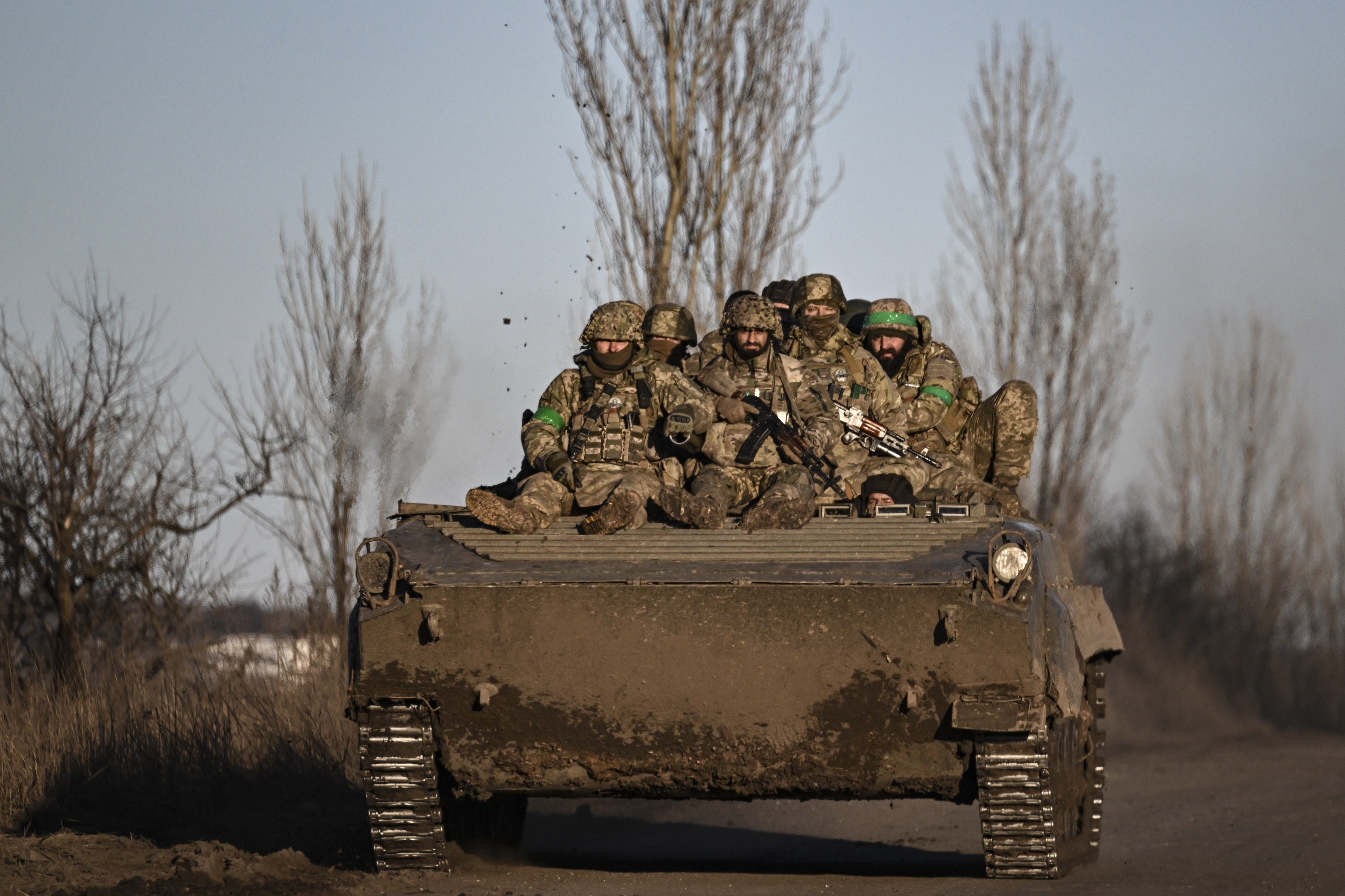 Ukrainian service members sit on a BMP military vehicle as they move towards Bakhmut in the region of Donbas, Ukraine, on March 13, 2023.
