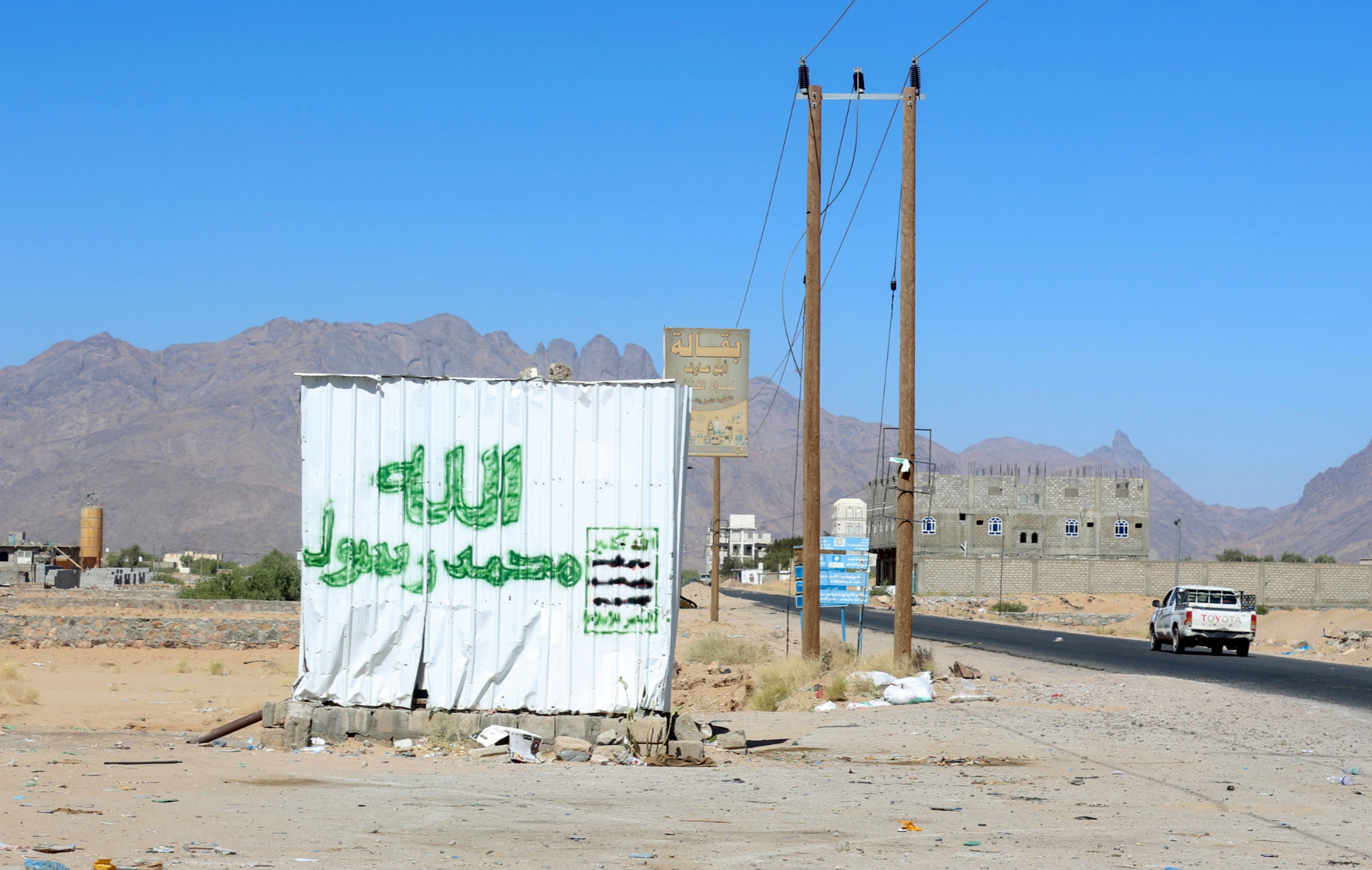 A pick-up truck drives down a road heading towards Yemen's al-Jawba town in the country's northeastern province of Marib on January 27, 2022, with a view of the Malaa mountain range in the background. (Photo by Saleh Al-OBEIDI / AFP)