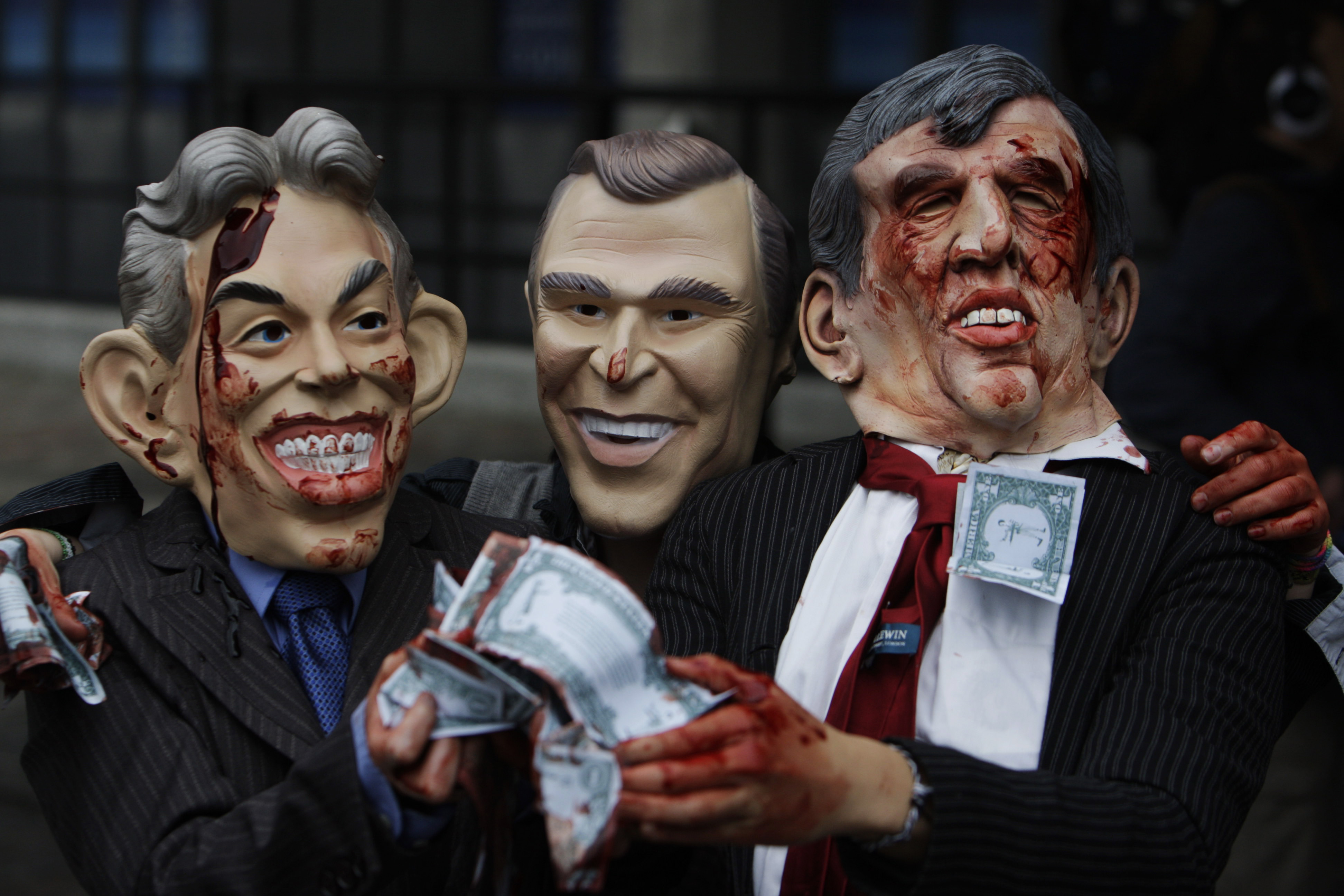 Anti-war protesters from the 'Stop the War' group, wearing rubber masks