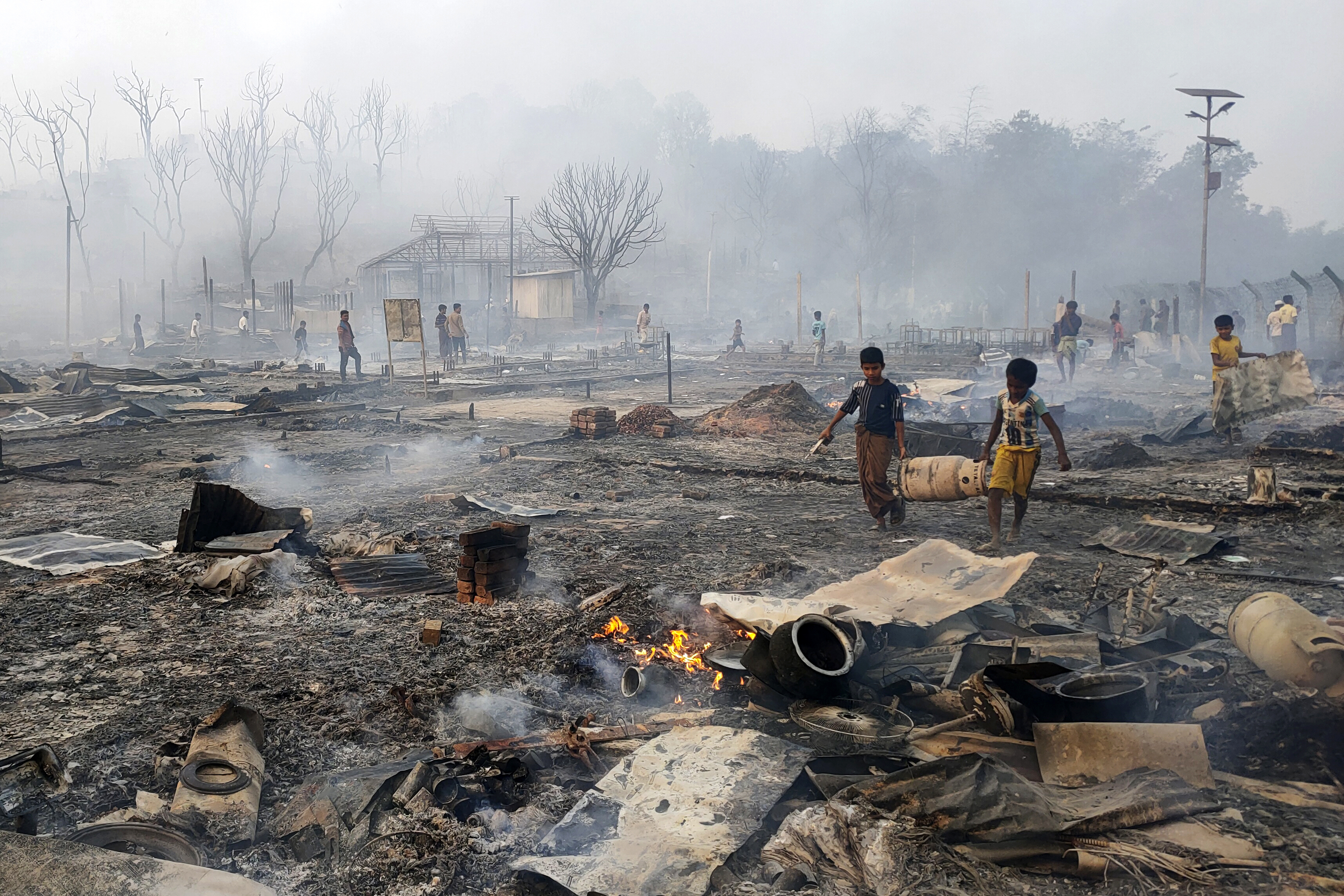 Rohingya refugee boys salvage a gas cylinder after a major fire in Balukhali camp at Ukhiya in Cox's Bazar district, Bangladesh